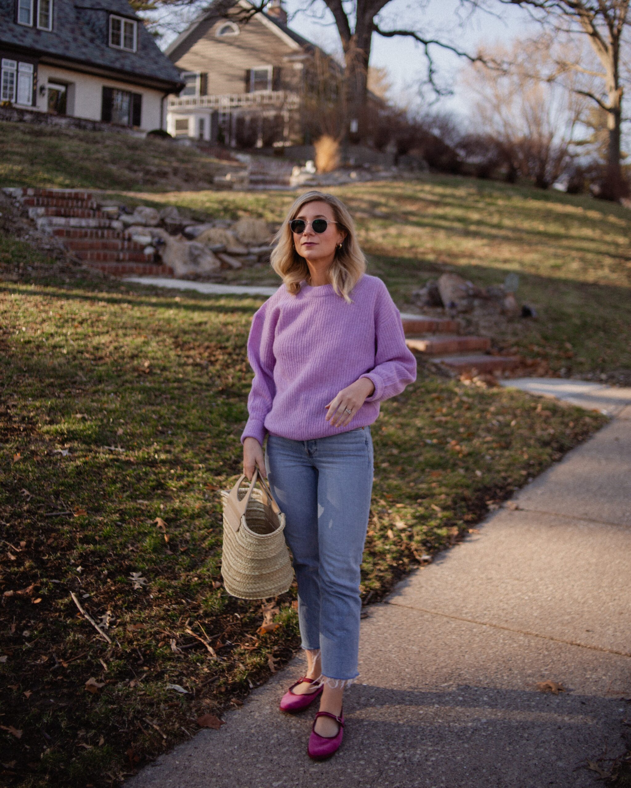 Karin Emily wears a purple sweater with light wash re/done jeans, and pink mary jane flats