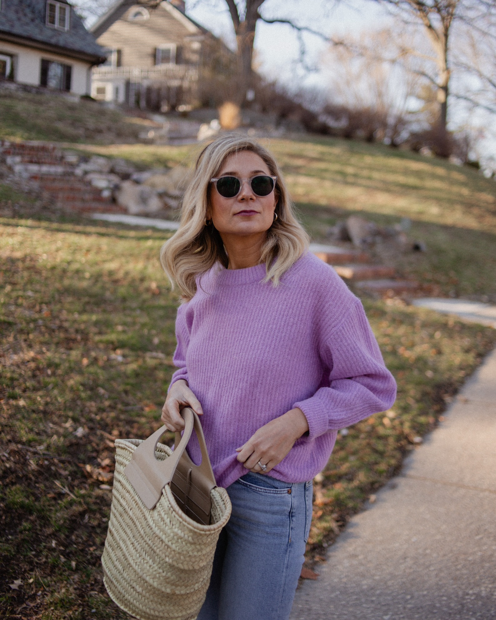 Karin Emily wears a purple sweater with light wash re/done jeans, and pink mary jane flats