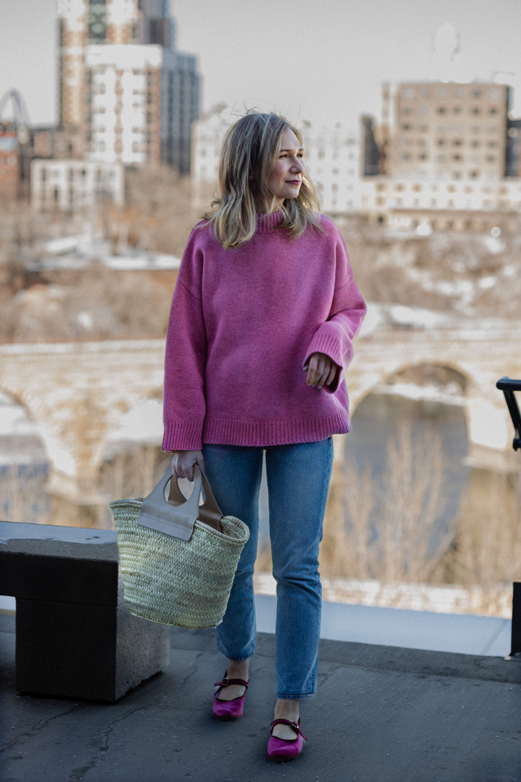 Karin Emily wears a pink sweater, blue jeans, and a pair of pink Mary Jane's