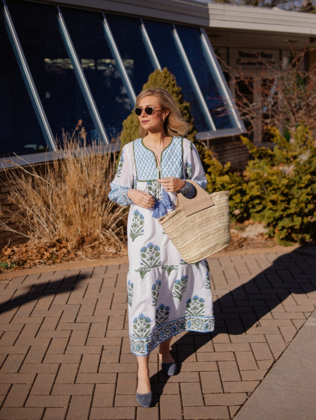 Karin Emily wears a blue and white SZ Block Prints Easter Dress paired with blue mules and a basket bag