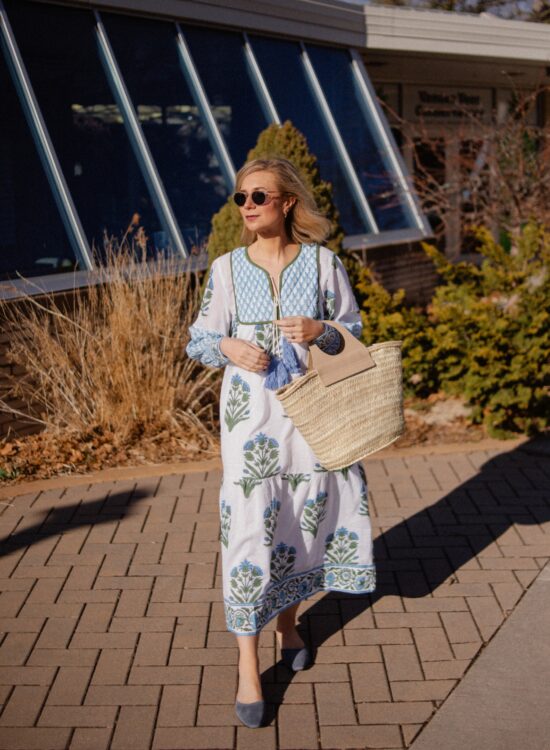 Karin Emily wears a blue and white SZ Block Prints Easter Dress paired with blue mules and a basket bag