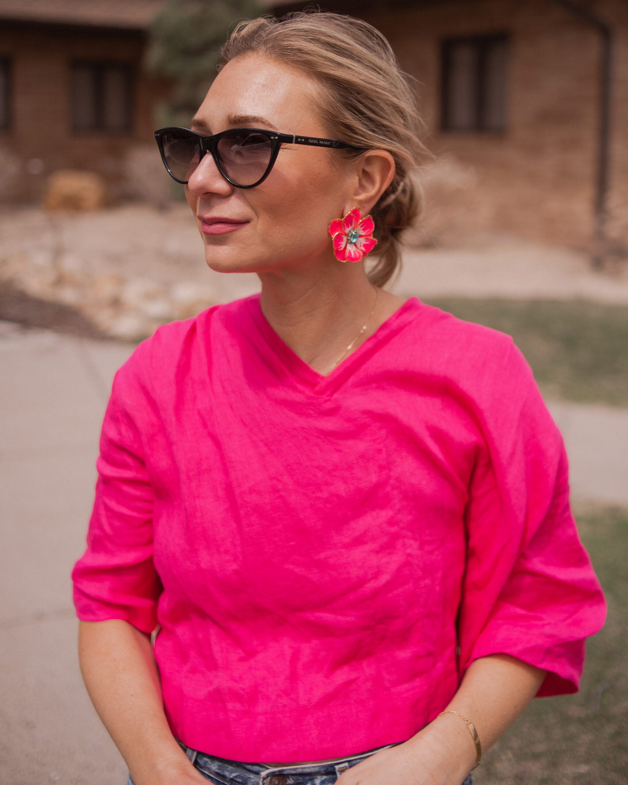 Karin Emily wears a fuchsia linen top from aliya wanek, hand painted flower earrings from the Pink Reef and Isabel Marant Sunglasses