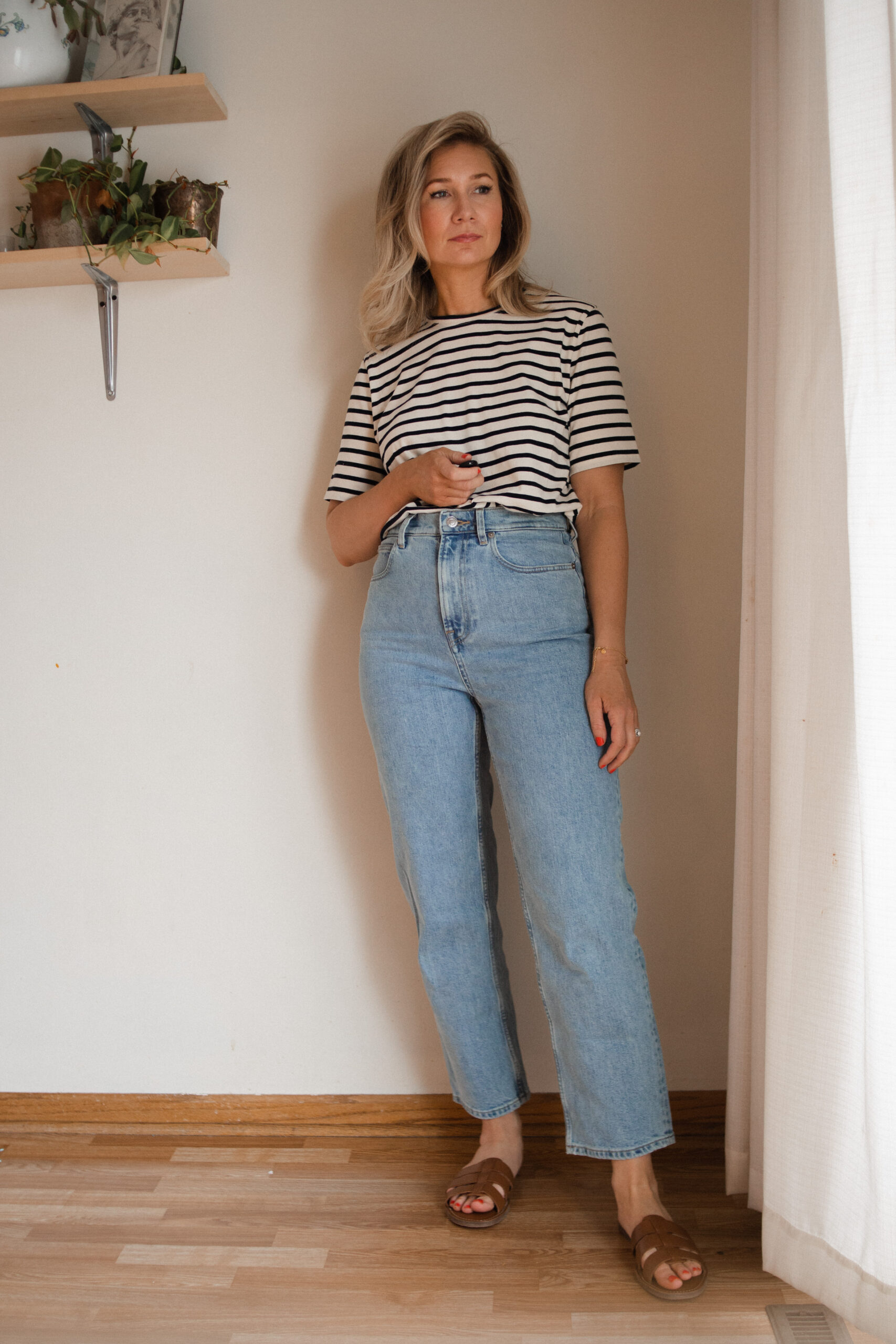 Karin Emily wears a black and white striped tee, the everlane rigid way high jeans and a pair of brown sandals for her Everlane Denim Guide