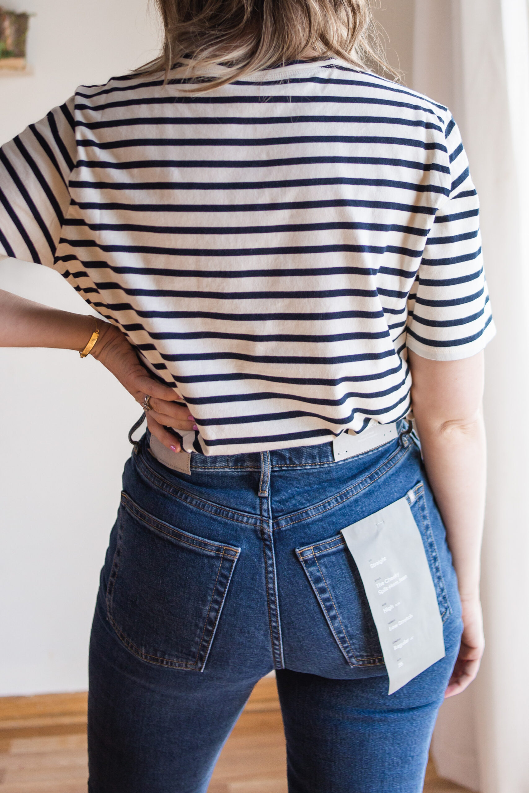Karin Emily wears a black and white striped tee and everlane cheeky split hem jeans
