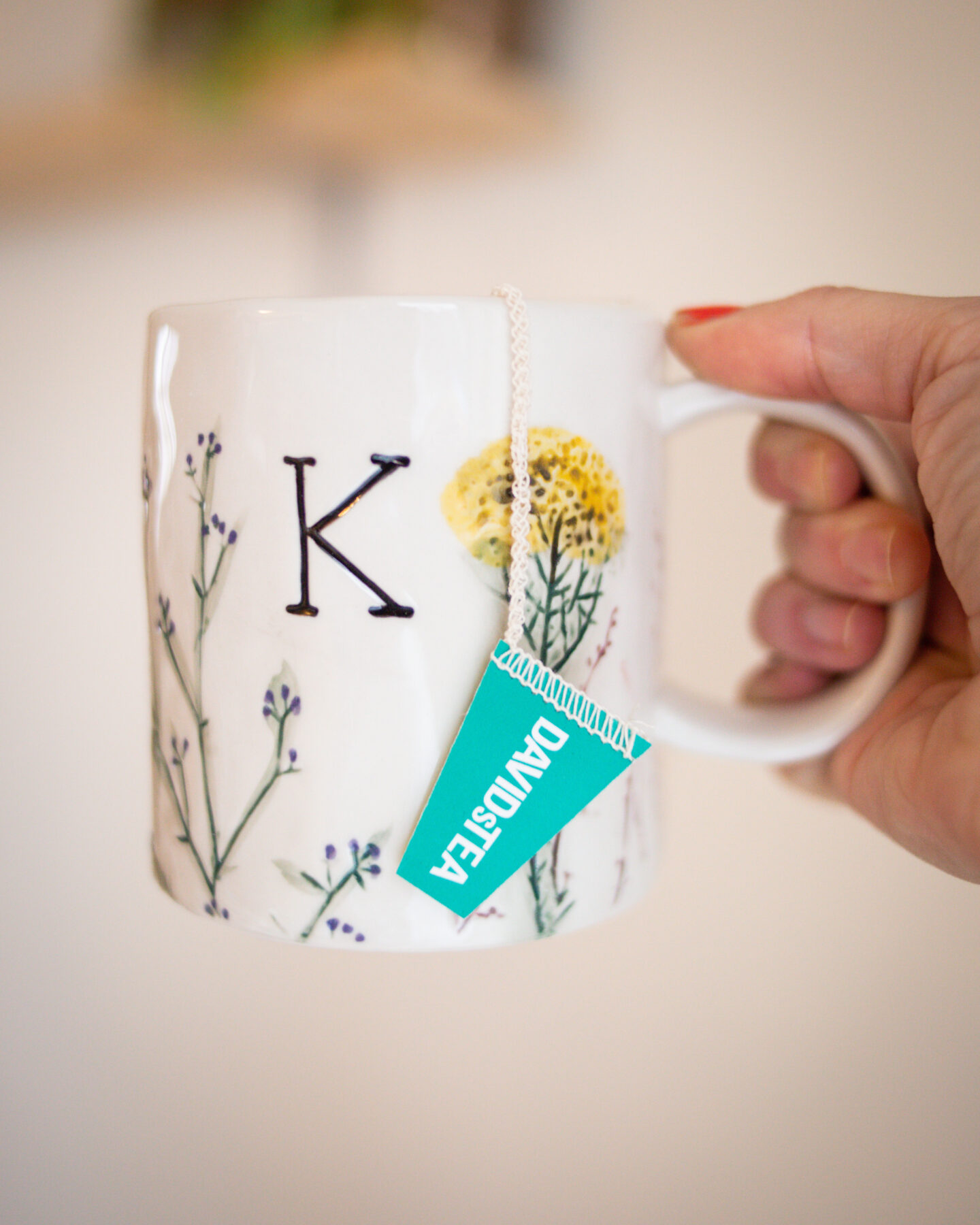 Karin Emily wears a monogrammed mug with a spring floral print for her Mother's Day Gift Guide