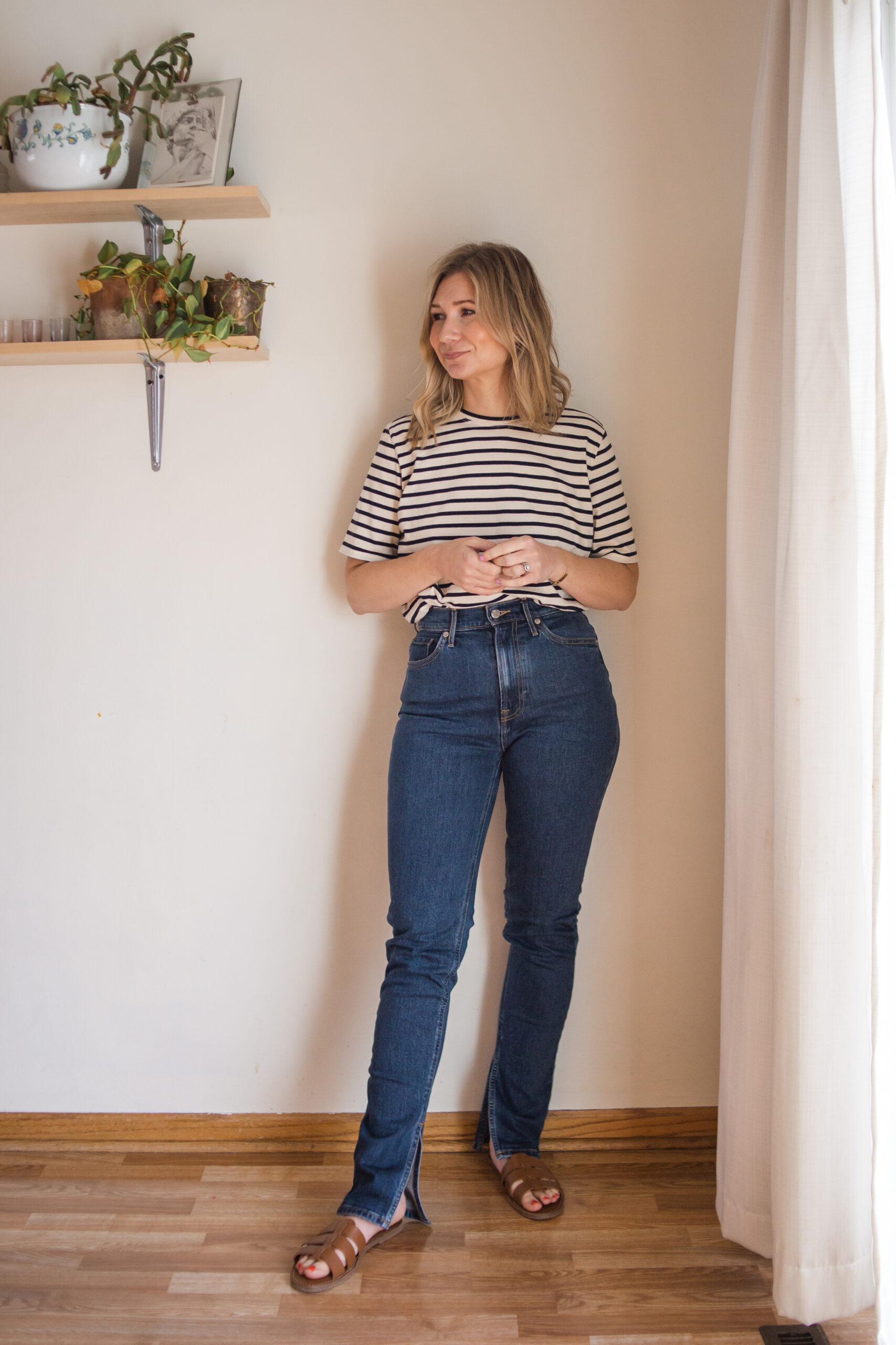 Karin Emily wears a black and white striped tee, everlane cheeky split hem jeans, and brown sandals