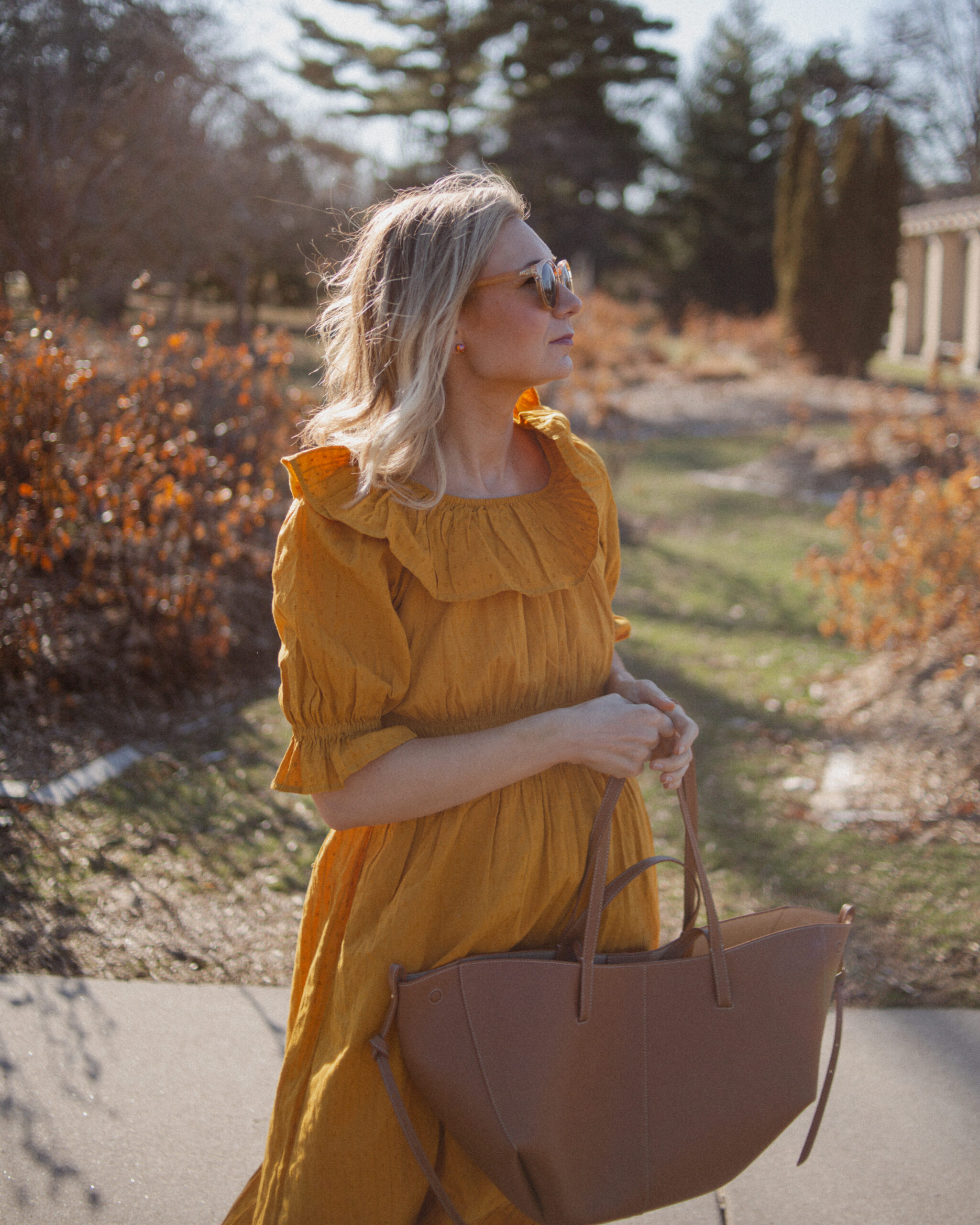 Karin Emily shares her favorites shoes for spring and wears a goldenrod yellow dress with a brown tote bag from Polene