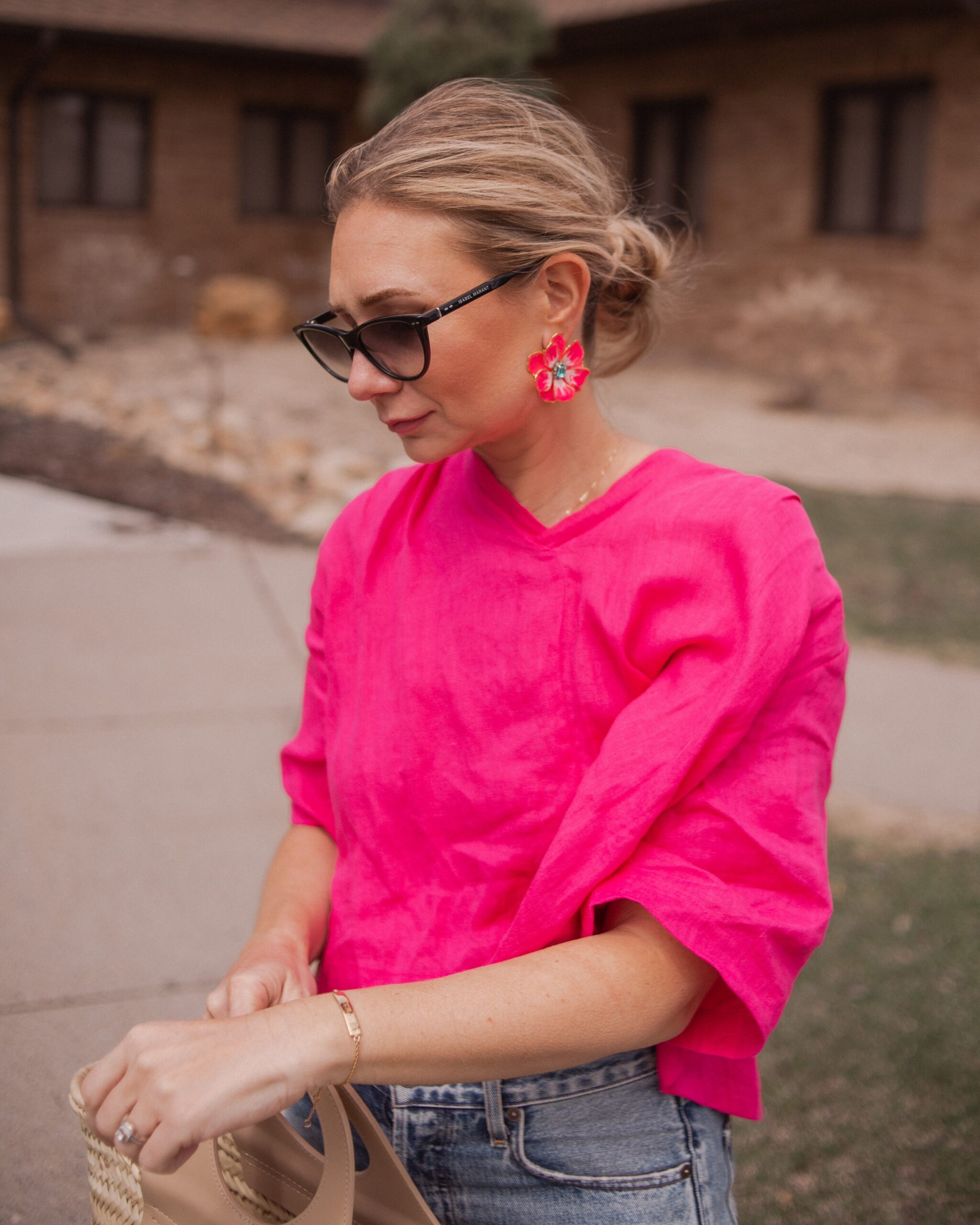 Karin Emily wears a fuchsia linen top from aliya wanek, hand painted flower earrings from the Pink Reef and Isabel Marant Sunglasses 
