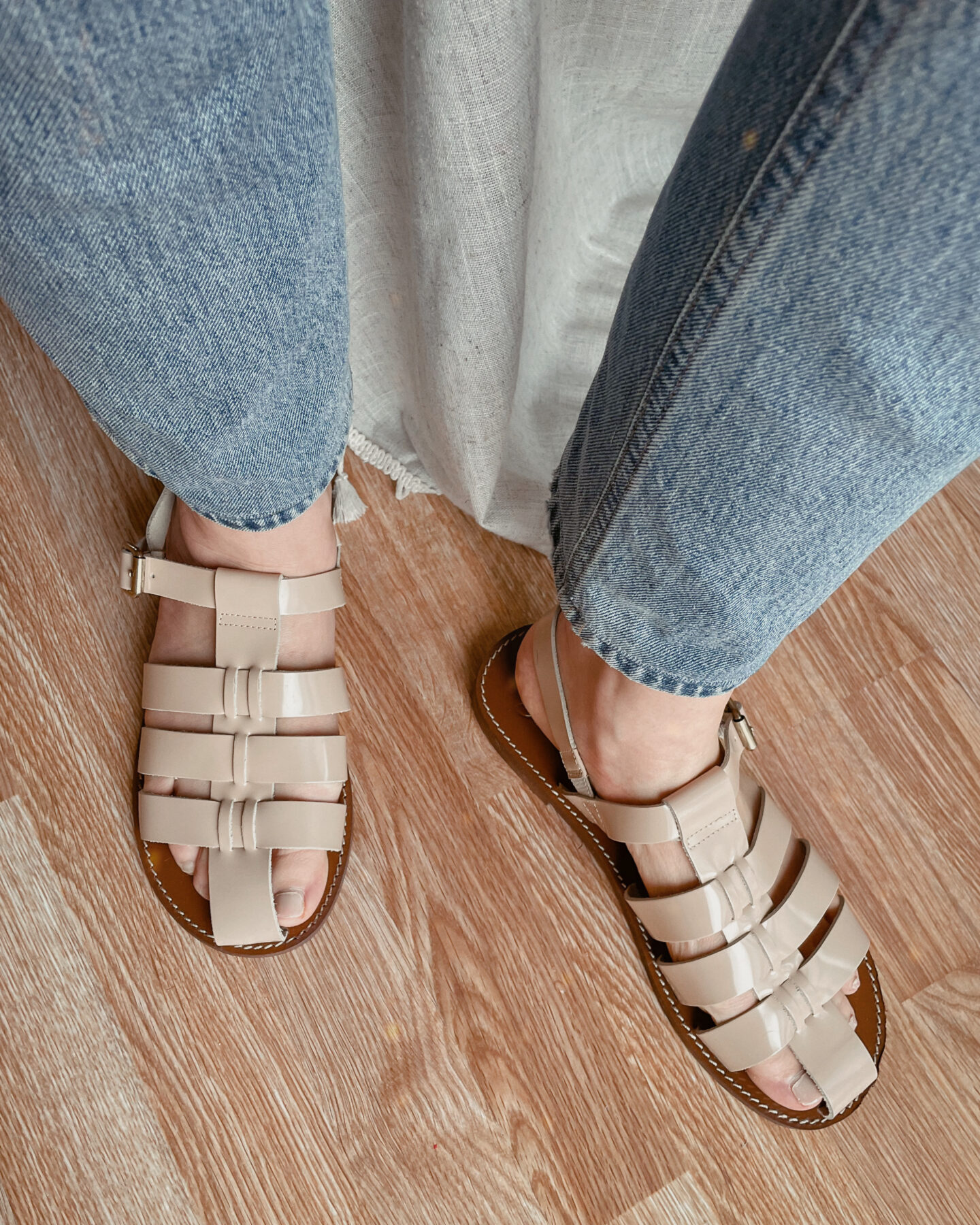 Karin Emily wears fisherman sandals with light wash jeans