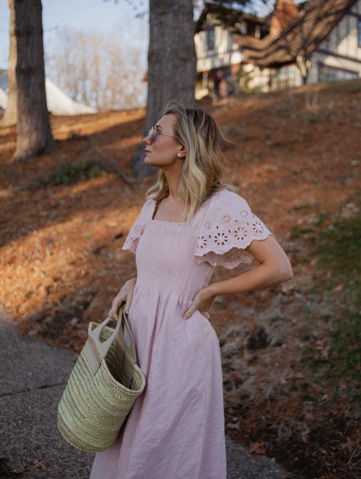Karin Emily wears a pink dress with a smocked bodice, and lace sleeves from her Madewell Sale Edit