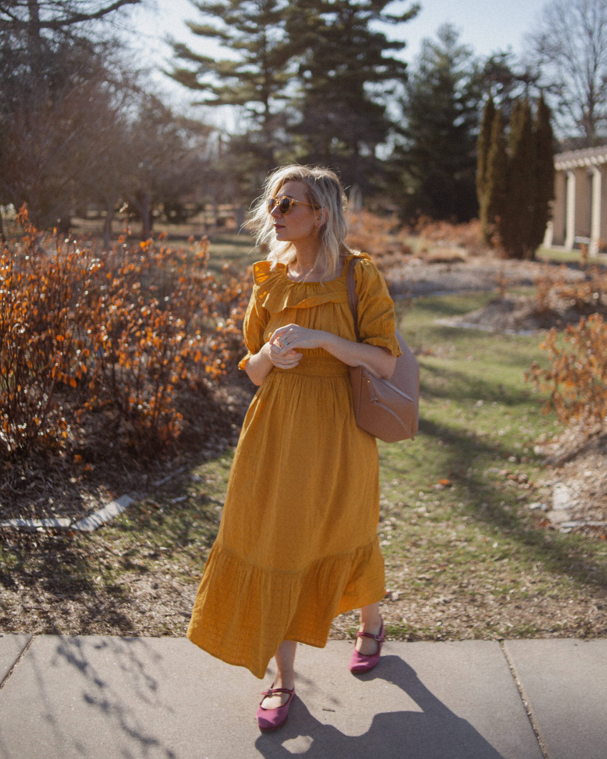 Karin Emily shares her favorites shoes for spring and wears a goldenrod yellow dress with a brown tote bag from Polene and pink mary jane flats