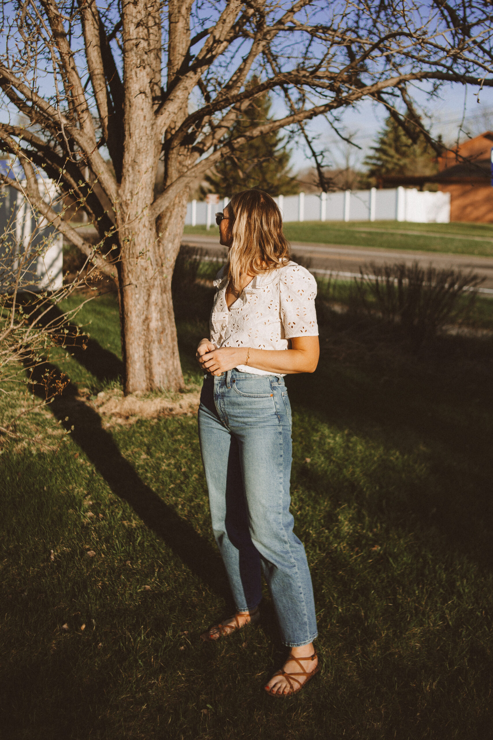 Karin Emily wears a white sezane top, wide leg Madewell jeans, and minimal ethically made sandals
