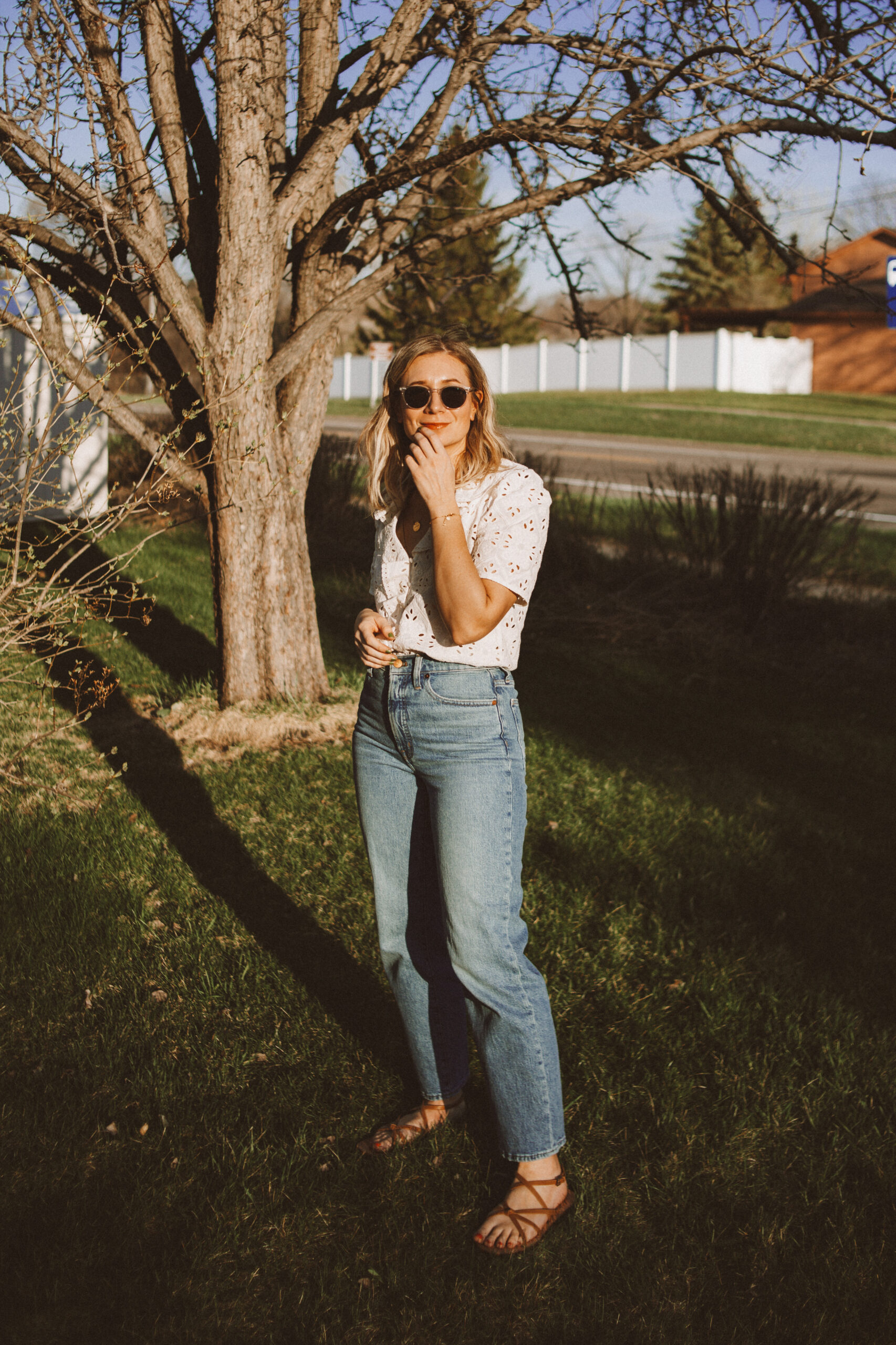Karin Emily wears a white sezane top, wide leg Madewell jeans, and minimal ethically made sandals