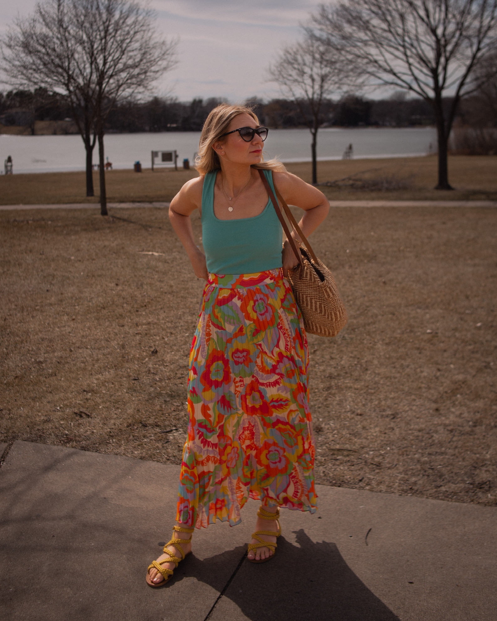 Karin Emily wears a turquoise juan t-shirt from Sezane with A brightly colored floral maxi skirt, yellow sandals,  and Isabel Marant Cat Eye Sunglasses