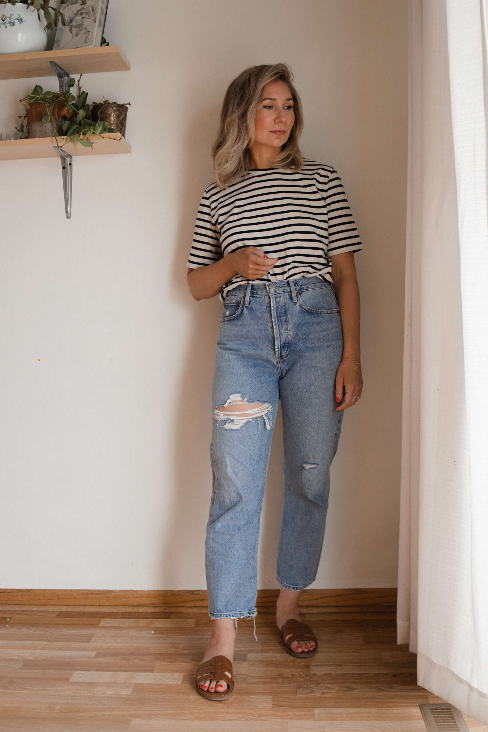 Karin Emily wears a pair of AGOLDE 90's straight jeans with a striped tee and brown sandals for her AGOLDE denim guide