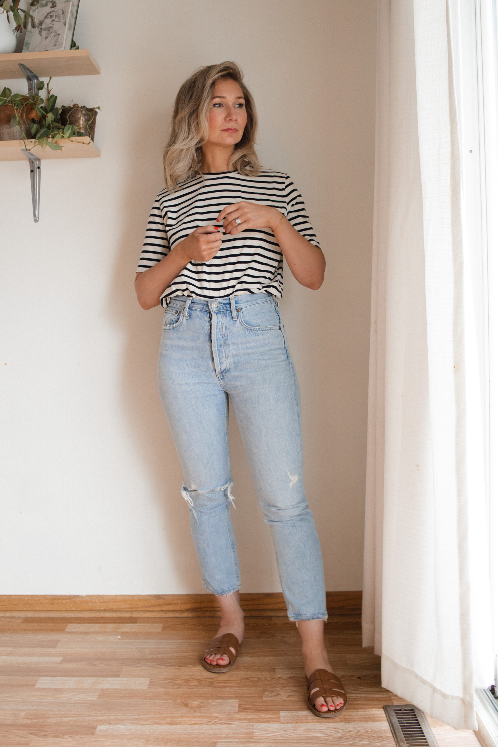 Karin Emily wears a pair of AGOLDE riley jeans with a striped tee and brown sandals for her AGOLDE denim guide