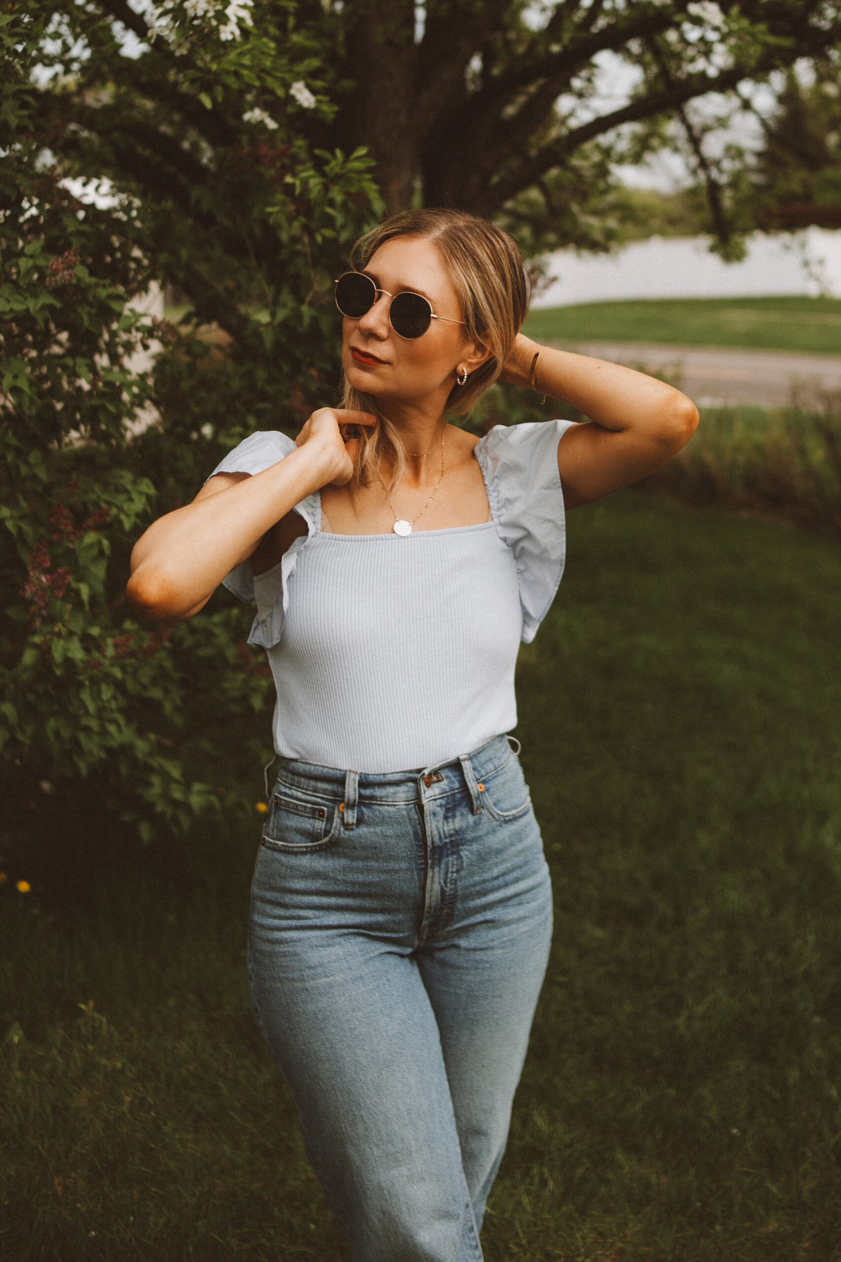 Karin Rambo wears a memorial day outfit with a blue flutter sleeve tank and blue denim jeans