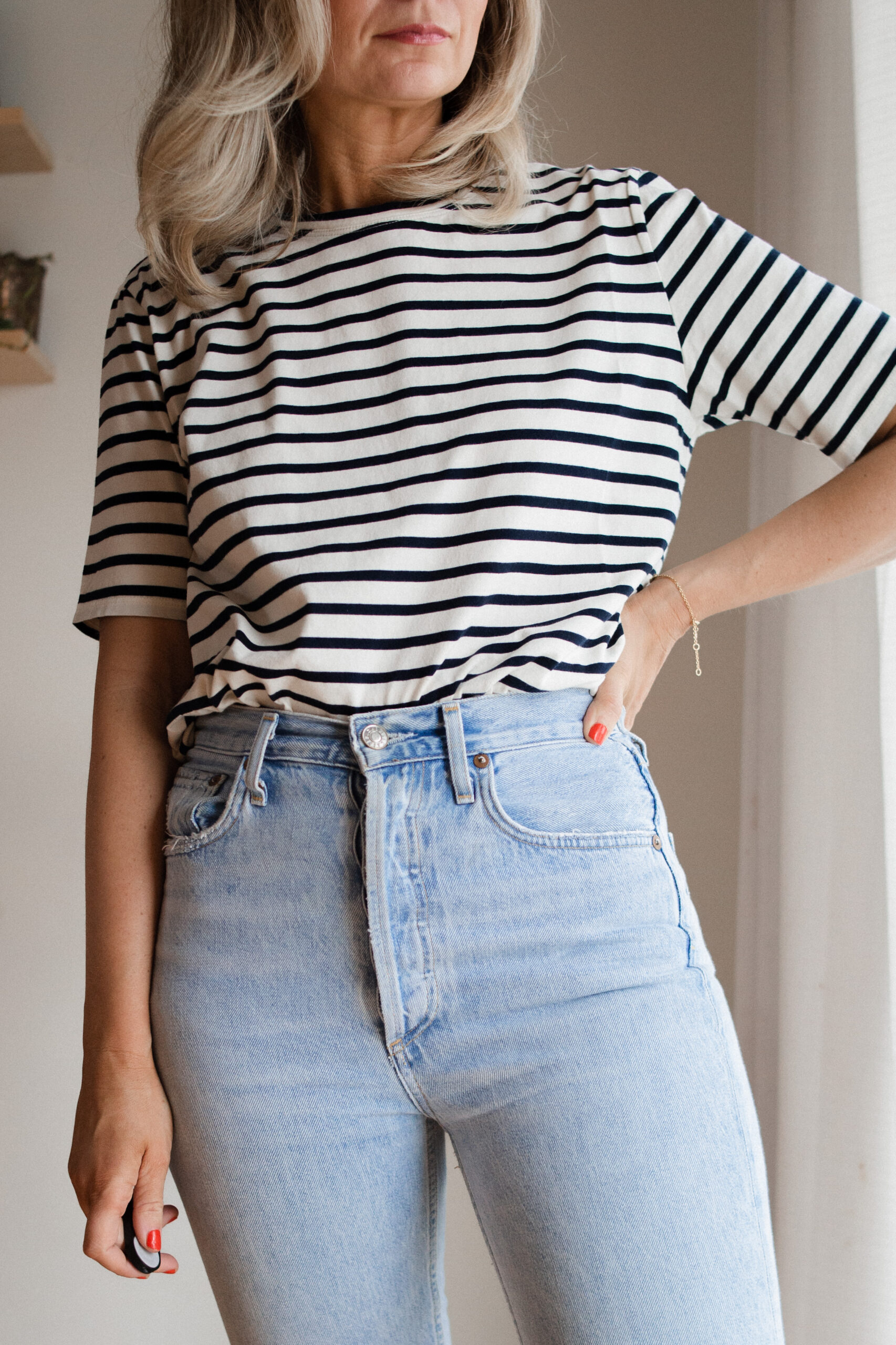 Karin Emily wears a pair of AGOLDE riley jeans with a striped tee and brown sandals for her AGOLDE denim guide