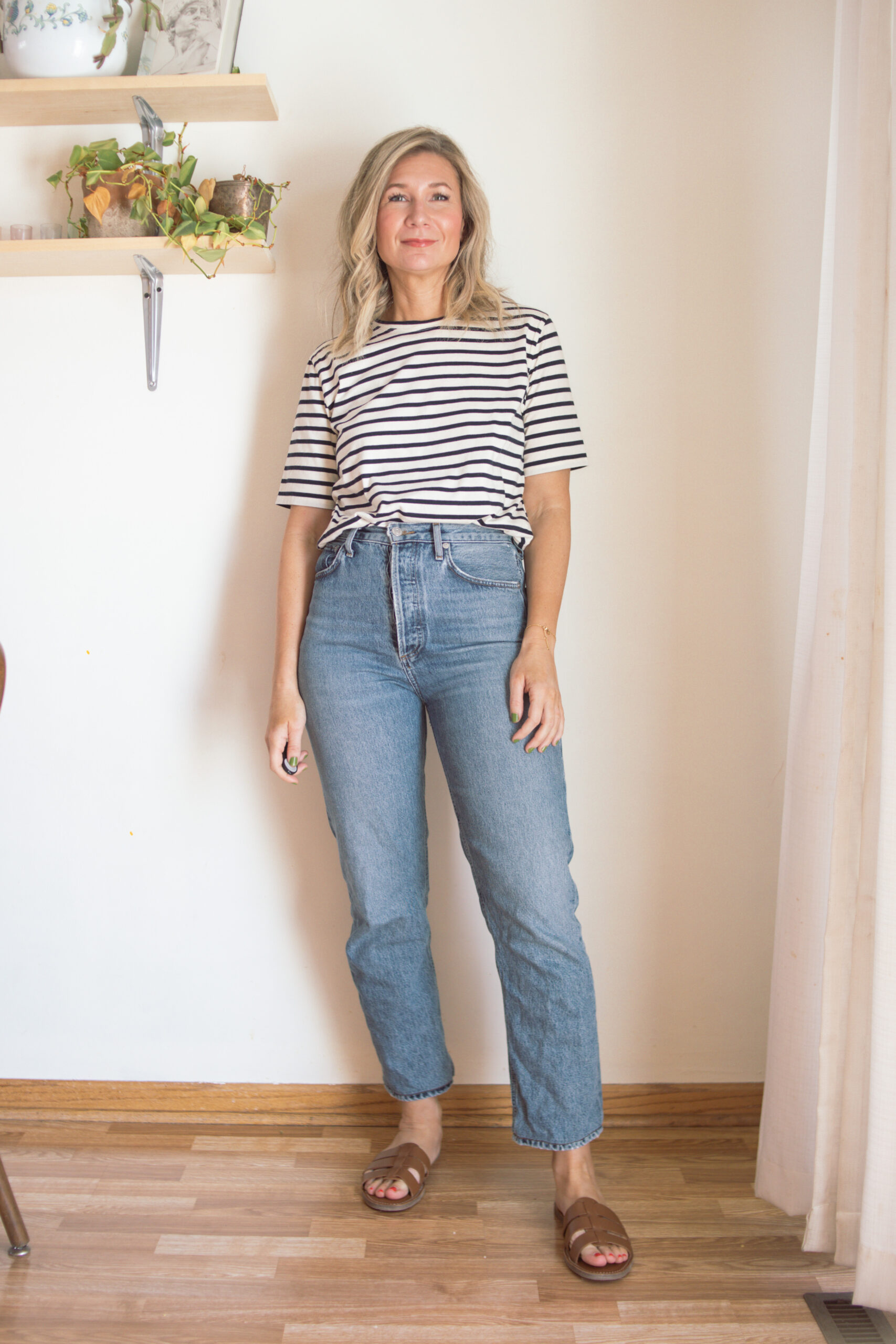 Karin Emily wears a pair of AGOLDE 90's pinch waist jeans with a striped tee and brown sandals for her AGOLDE denim guide
