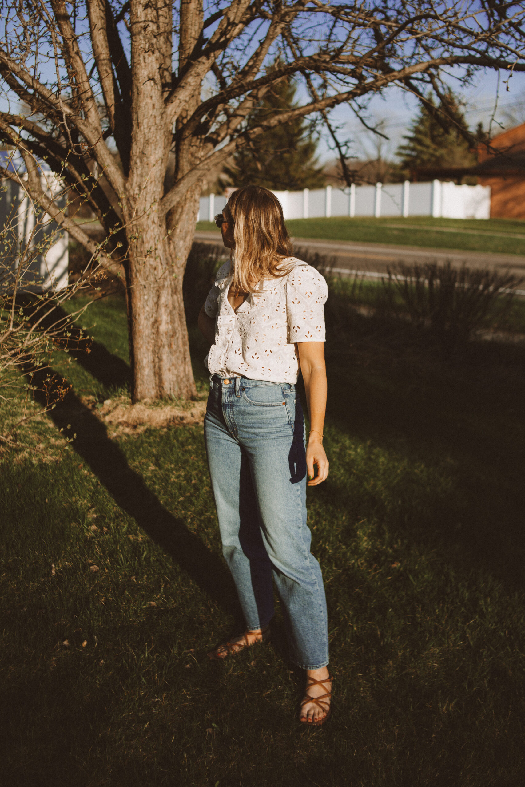 Karin Emily wears a white sezane top, wide leg Madewell jeans, and minimal ethically made sandals