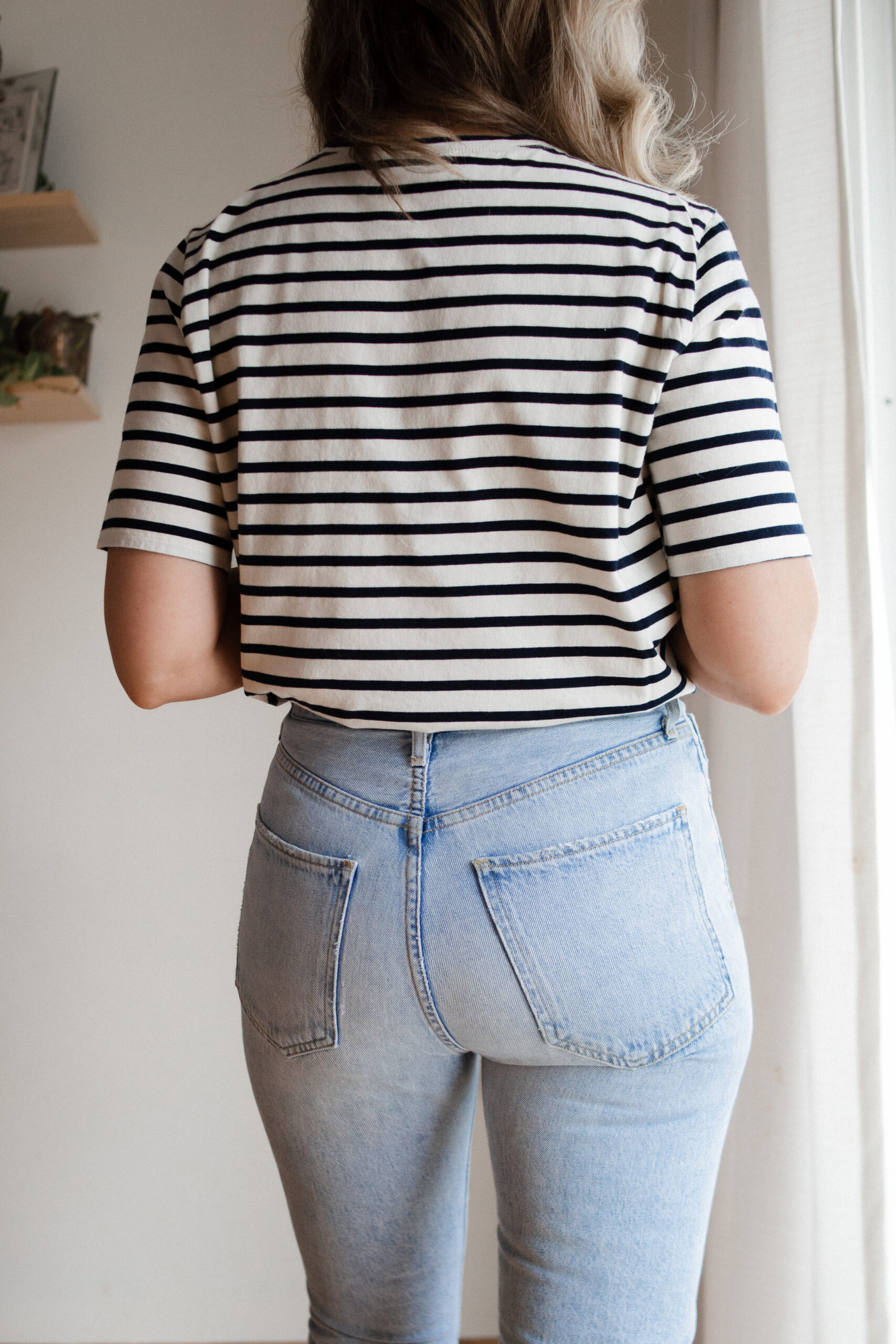 Karin Emily wears a pair of AGOLDE riley jeans with a striped tee and brown sandals for her AGOLDE denim guide