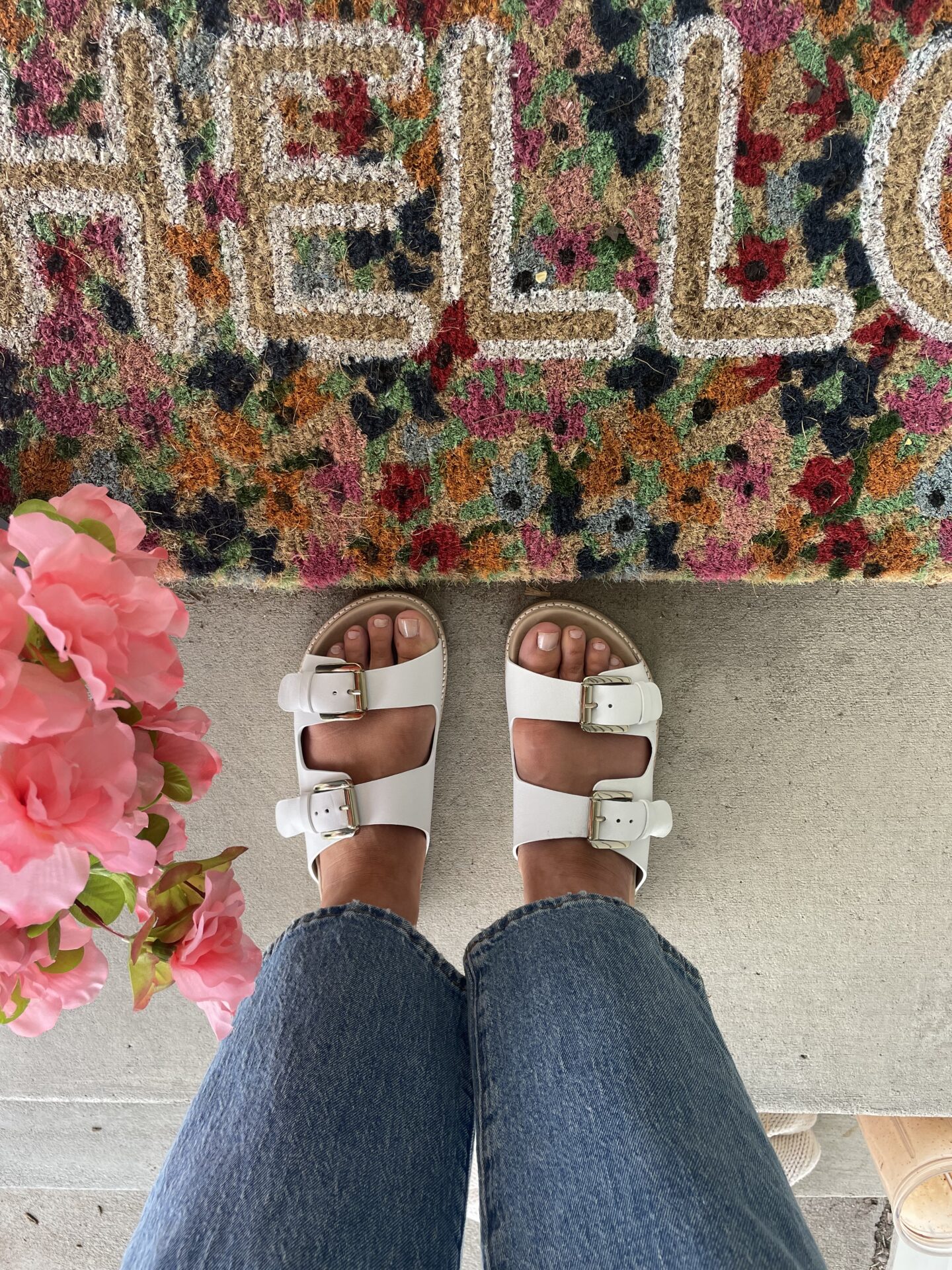 Karin Emily wears a pair of white double strap sandals, blue wide leg jeans, and white double strap sandals as part of an ABLE Spring Try On