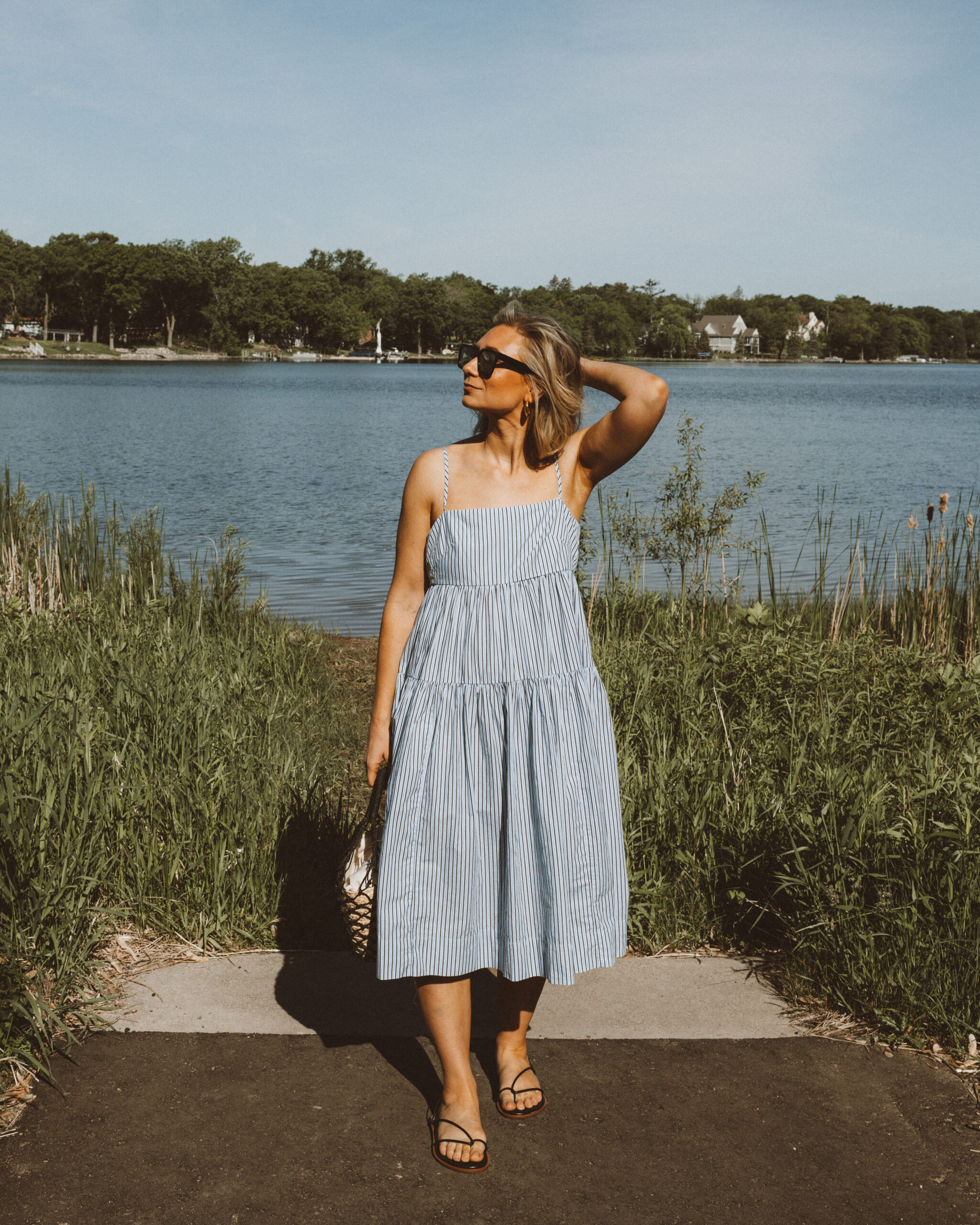 Karin Emily wears a vacation ready outfit: blue and white striped sundress from J. Crew
