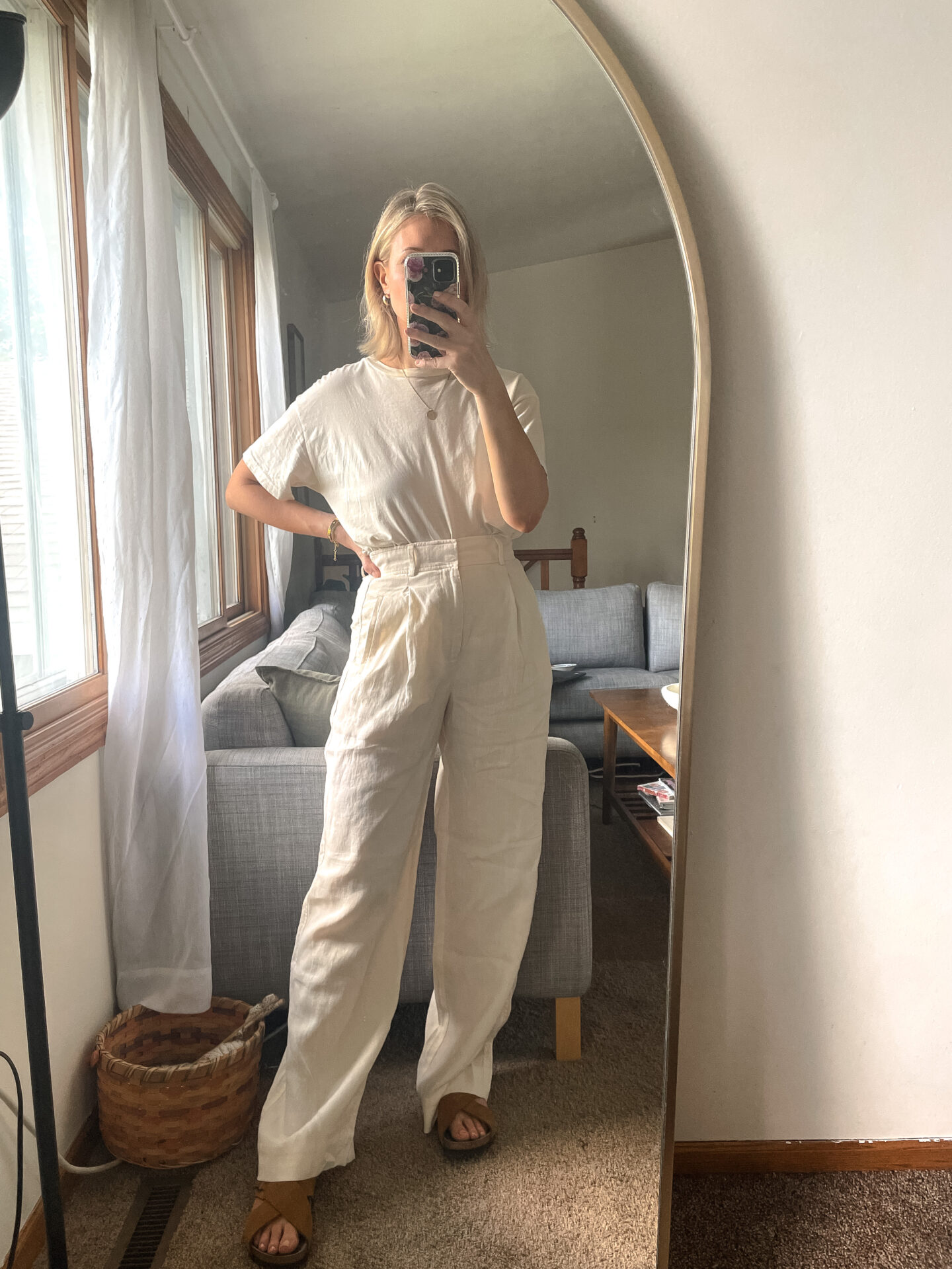 Karin Emily wears a pair of Everlane Pants with a white tank and birkenstock sandals
