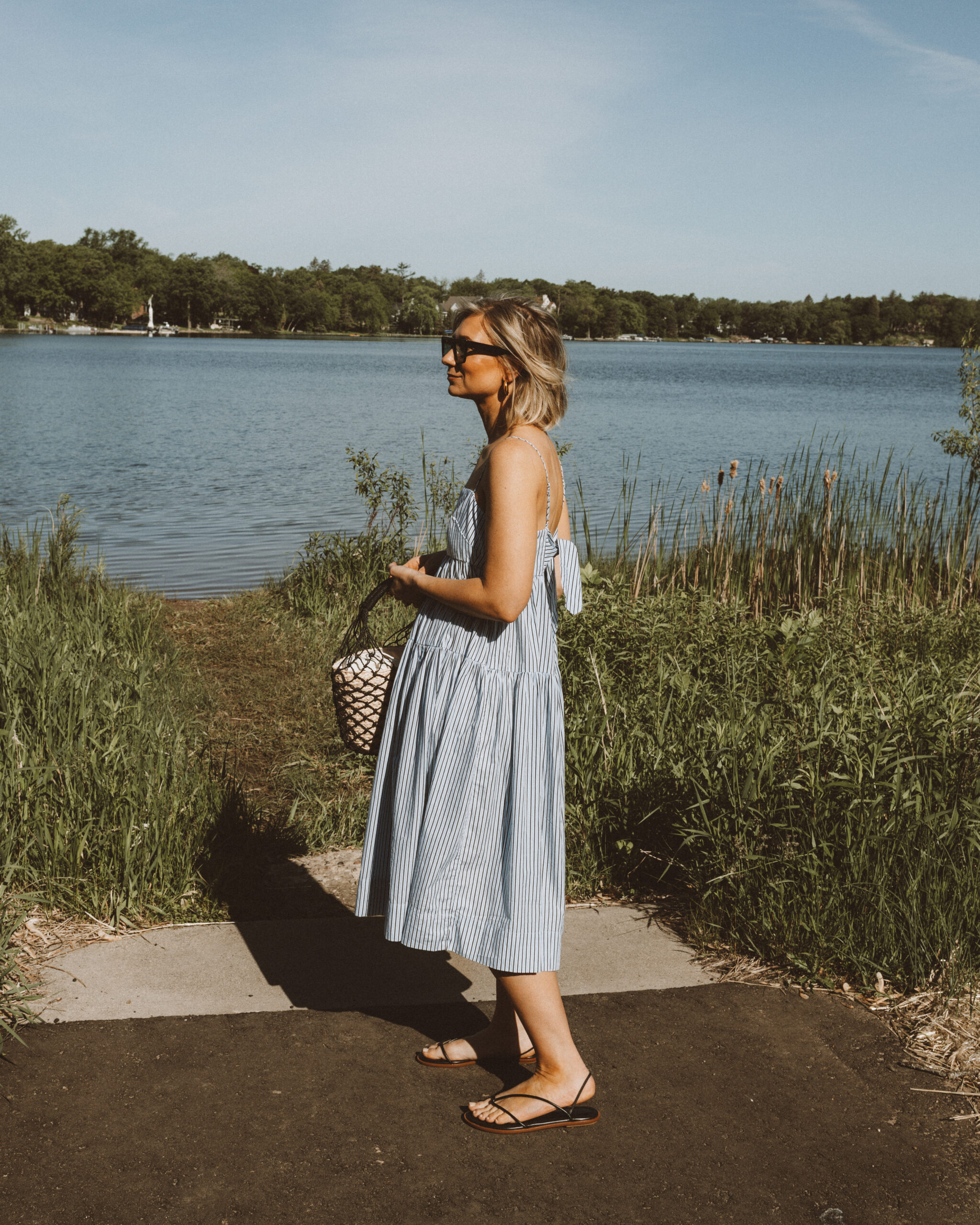 Karin Emily wears a vacation ready outfit: blue and white striped sundress from J. Crew