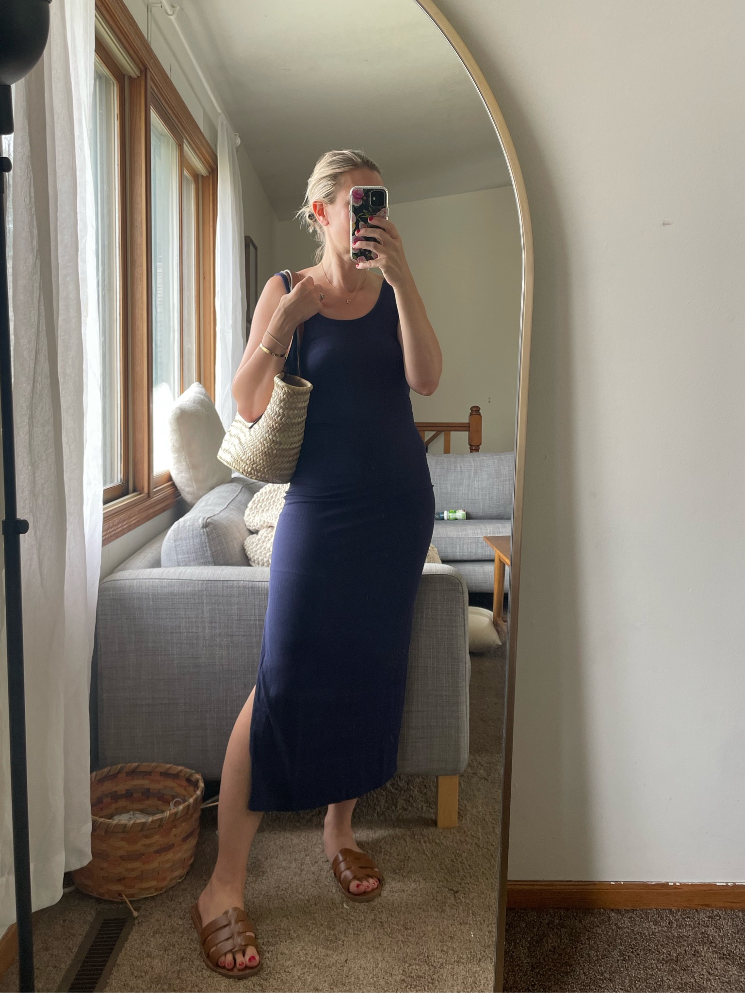 Karin Emily wears a navy blue midi dress with a basket bag and brown slide sandals