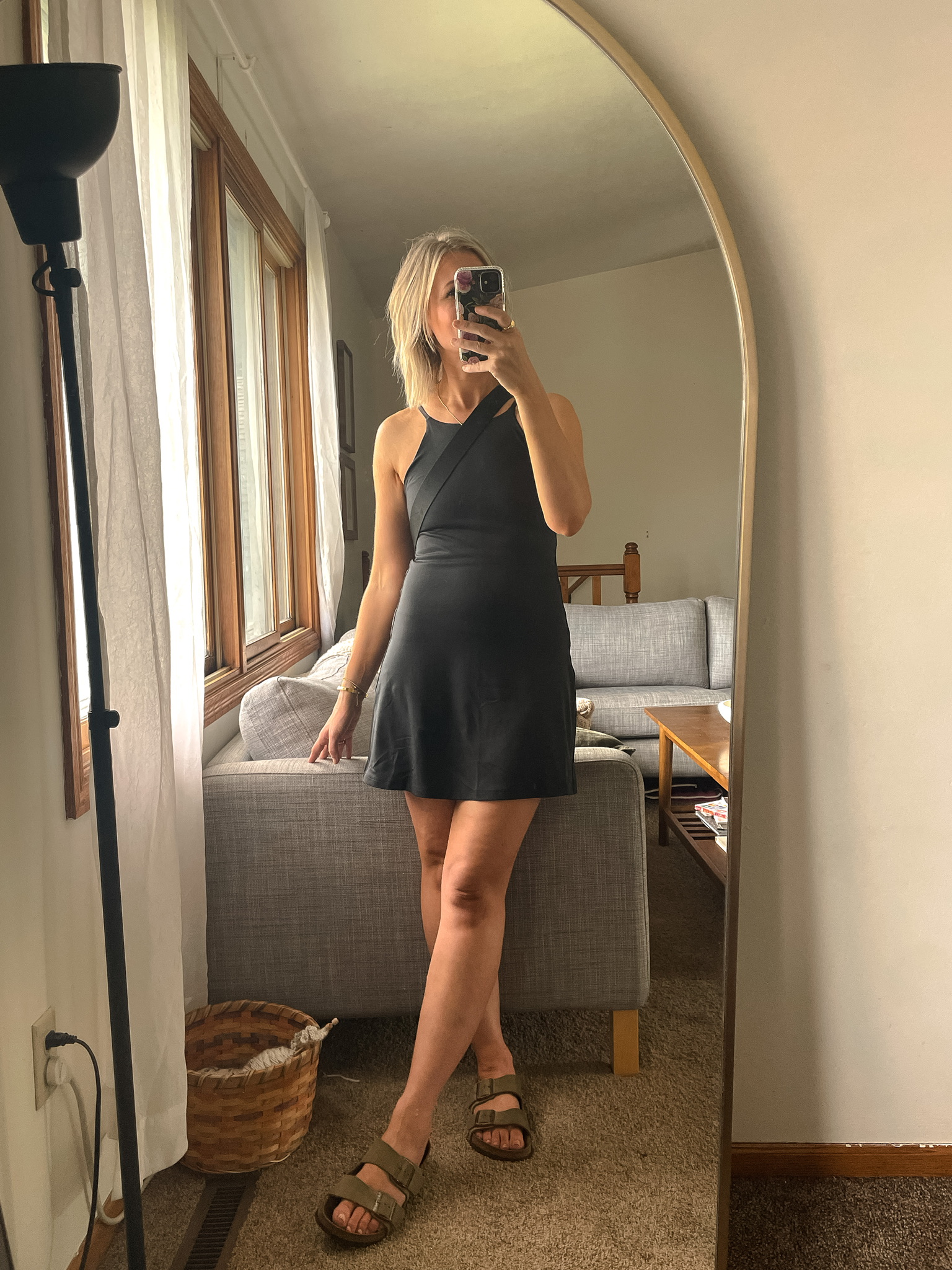 Karin Emily wears a black workout dress from Girlfriend and Birkenstock Arizona Sandals