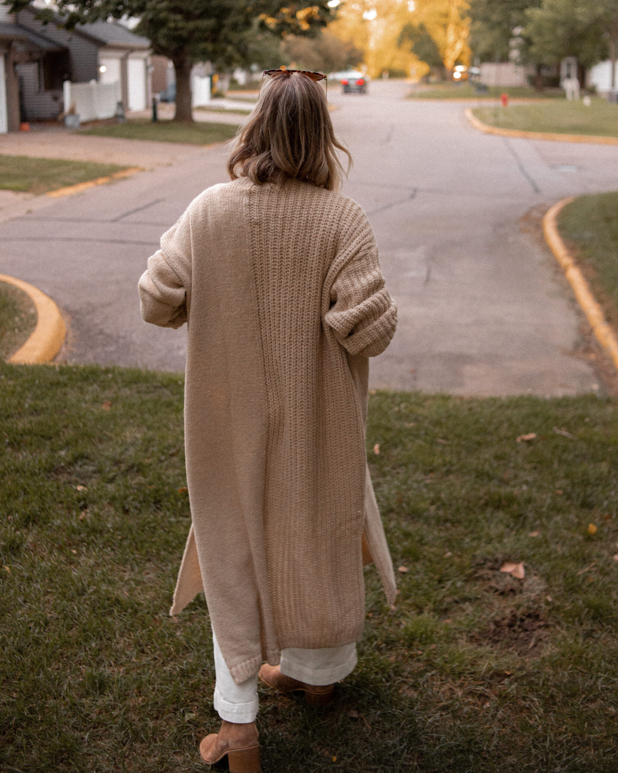 Karin Emily wears a long maxi cardigan and brown suede boots from the Nordstrom Anniversary Sale