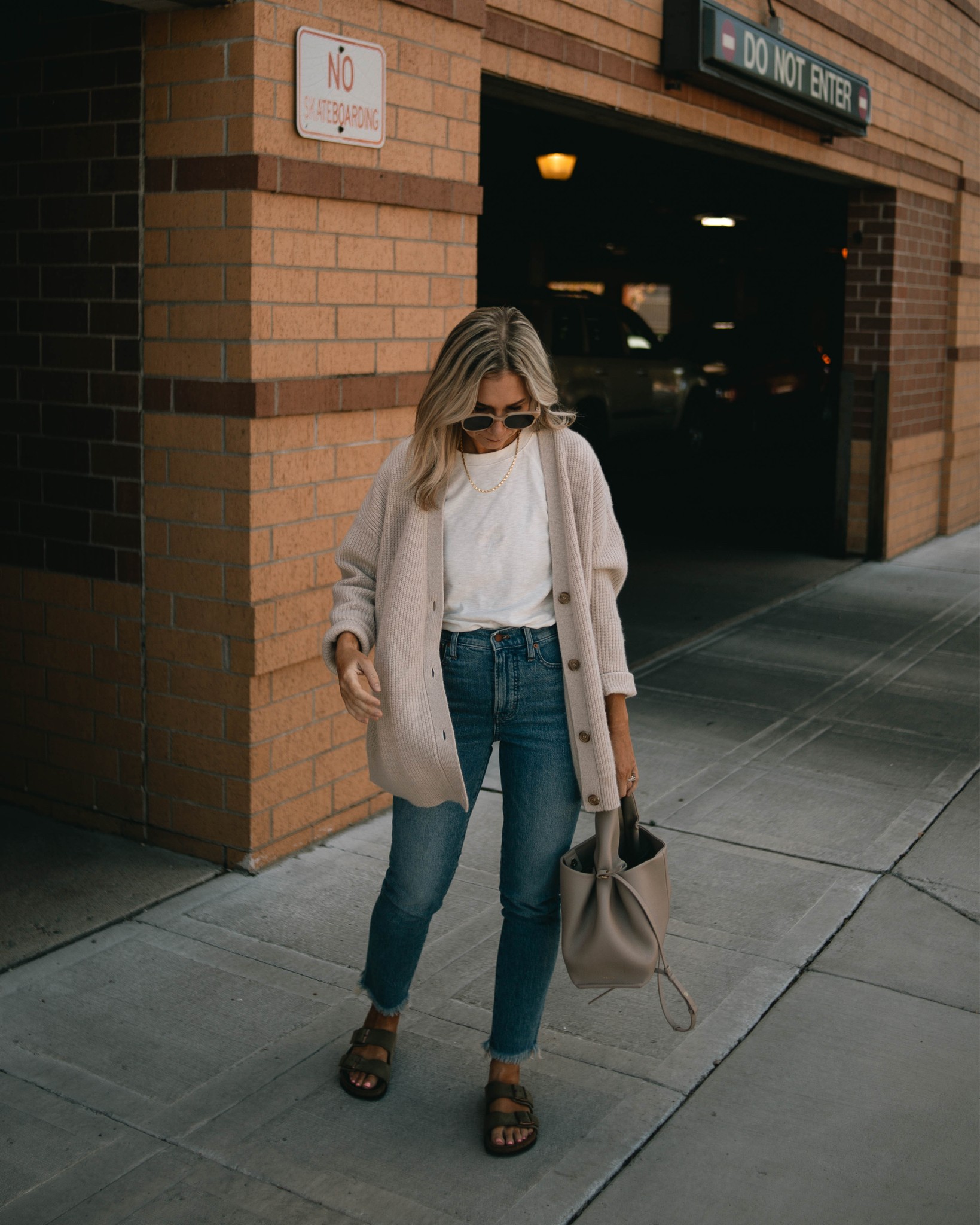 Karin Emily wears a white tee, cashmere cocoon cardigan from Jenni Kayne, perfect vintage jeans from Madewell and a Polene bag