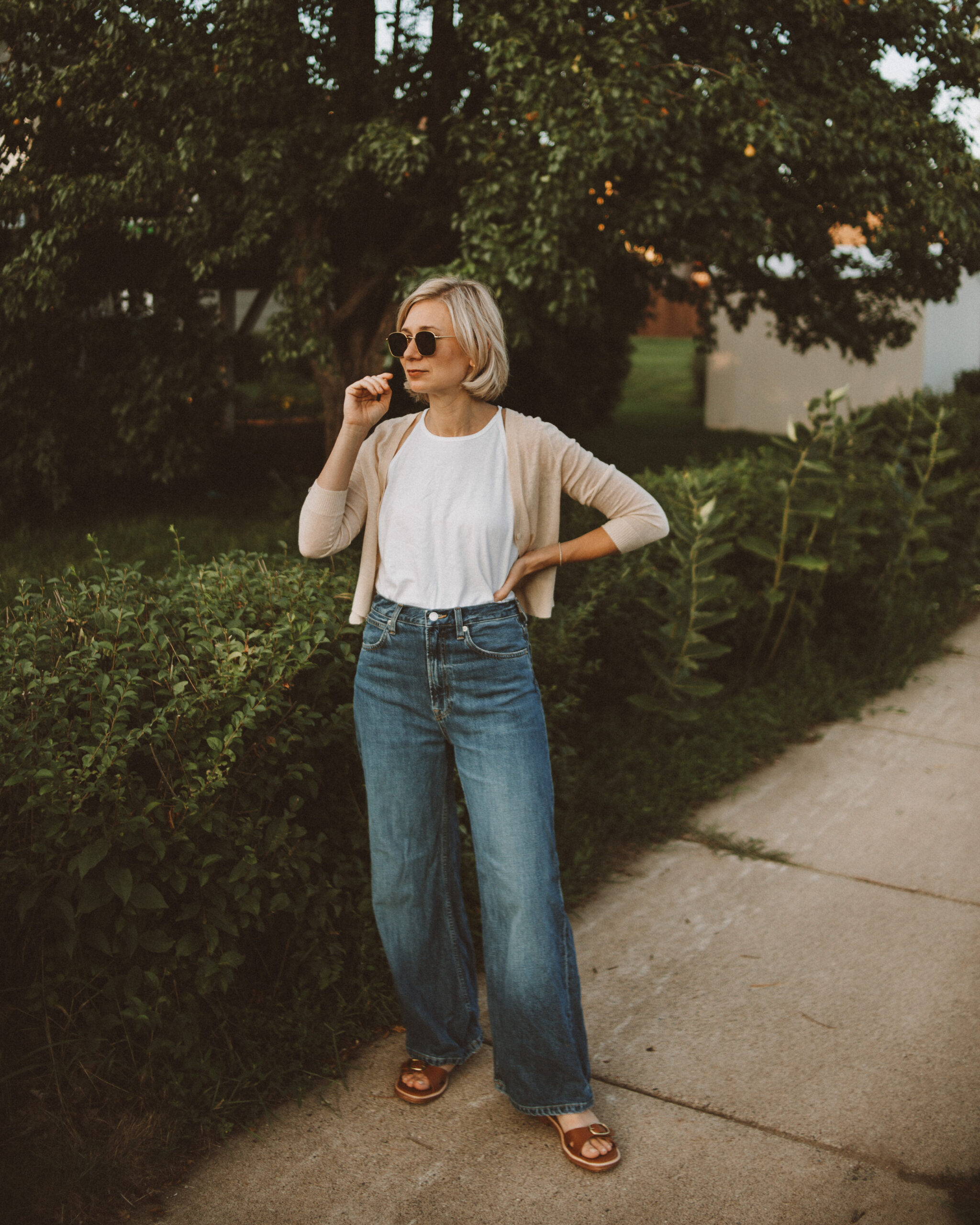 Karin Emily wears a 90s inspired outfit from Everlane with a white tank top, cropped cardigan, and dark wash wide leg jeans