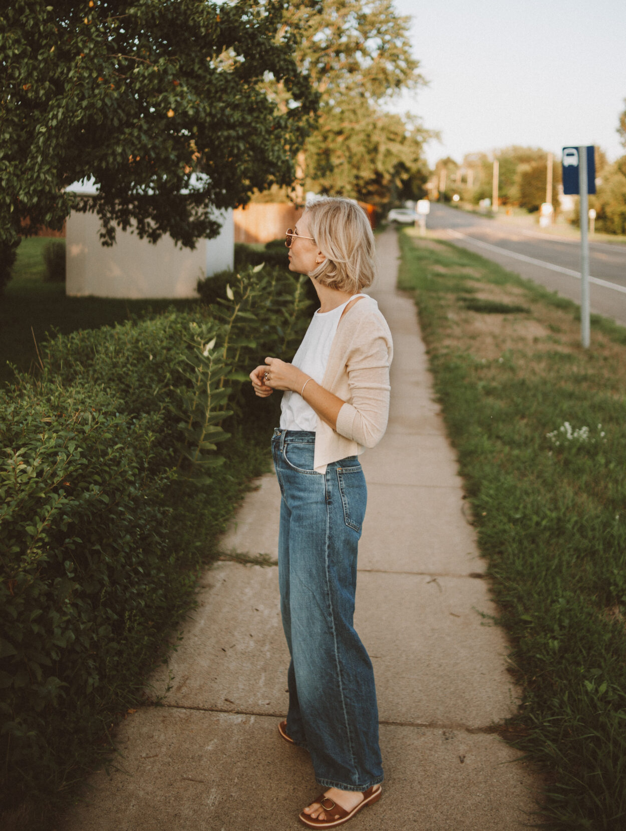 Karin Emily wears a 90s inspired outfit from Everlane with a white tank top, cropped cardigan, and dark wash wide leg jeans