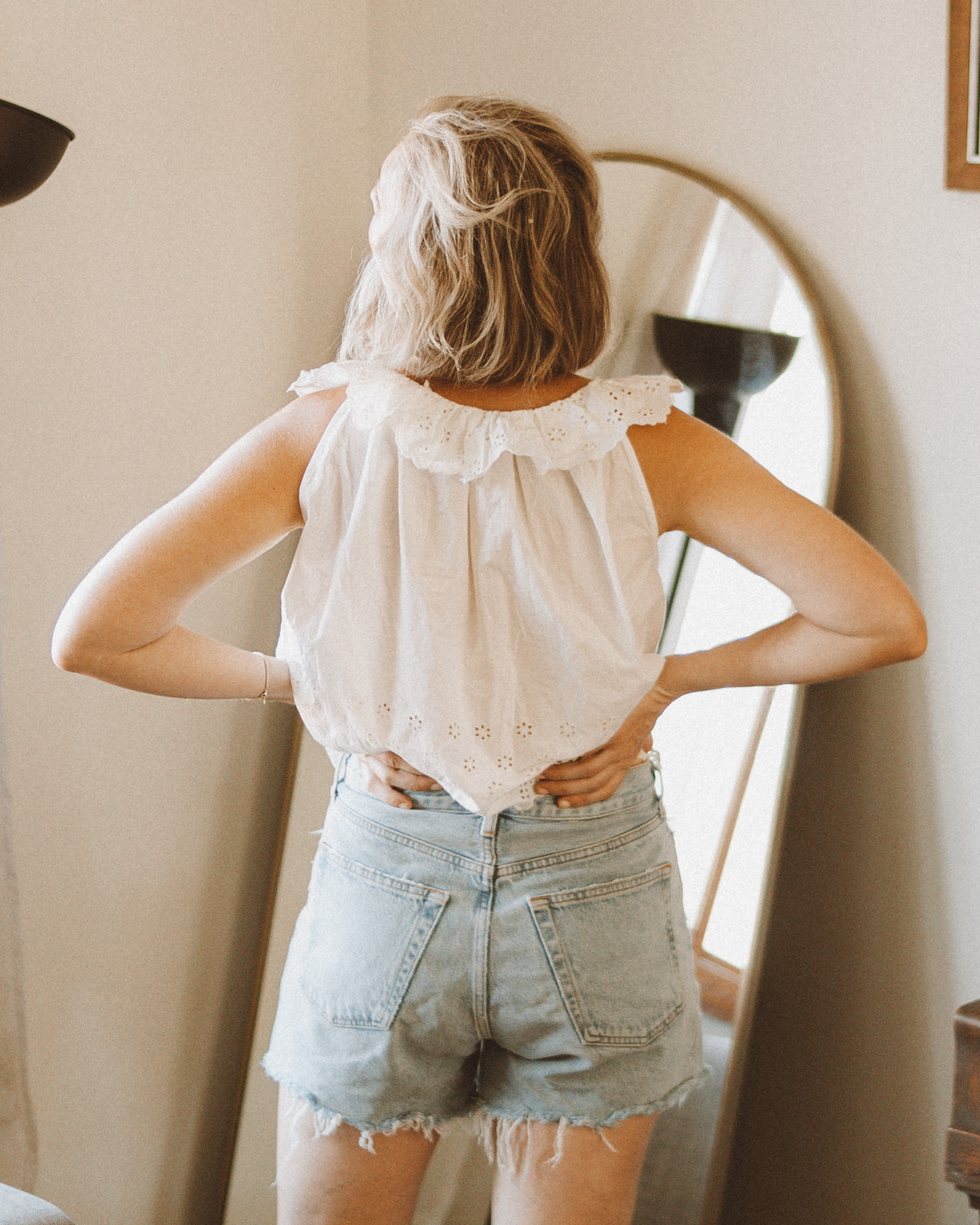 Karin Emily wears a white eyelet tank top and agolde parker shorts for an agolde jean short review