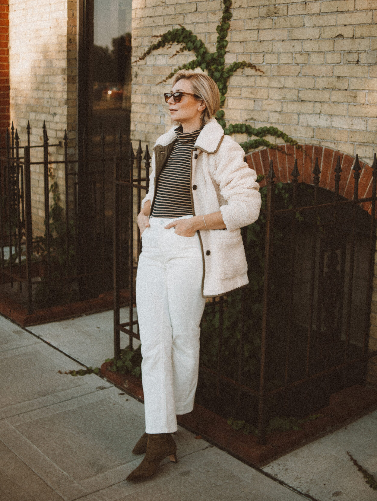Karin Emily wears the perfect pair of corduroy pants with a striped turtleneck, sherpa jacket, and heeled booties