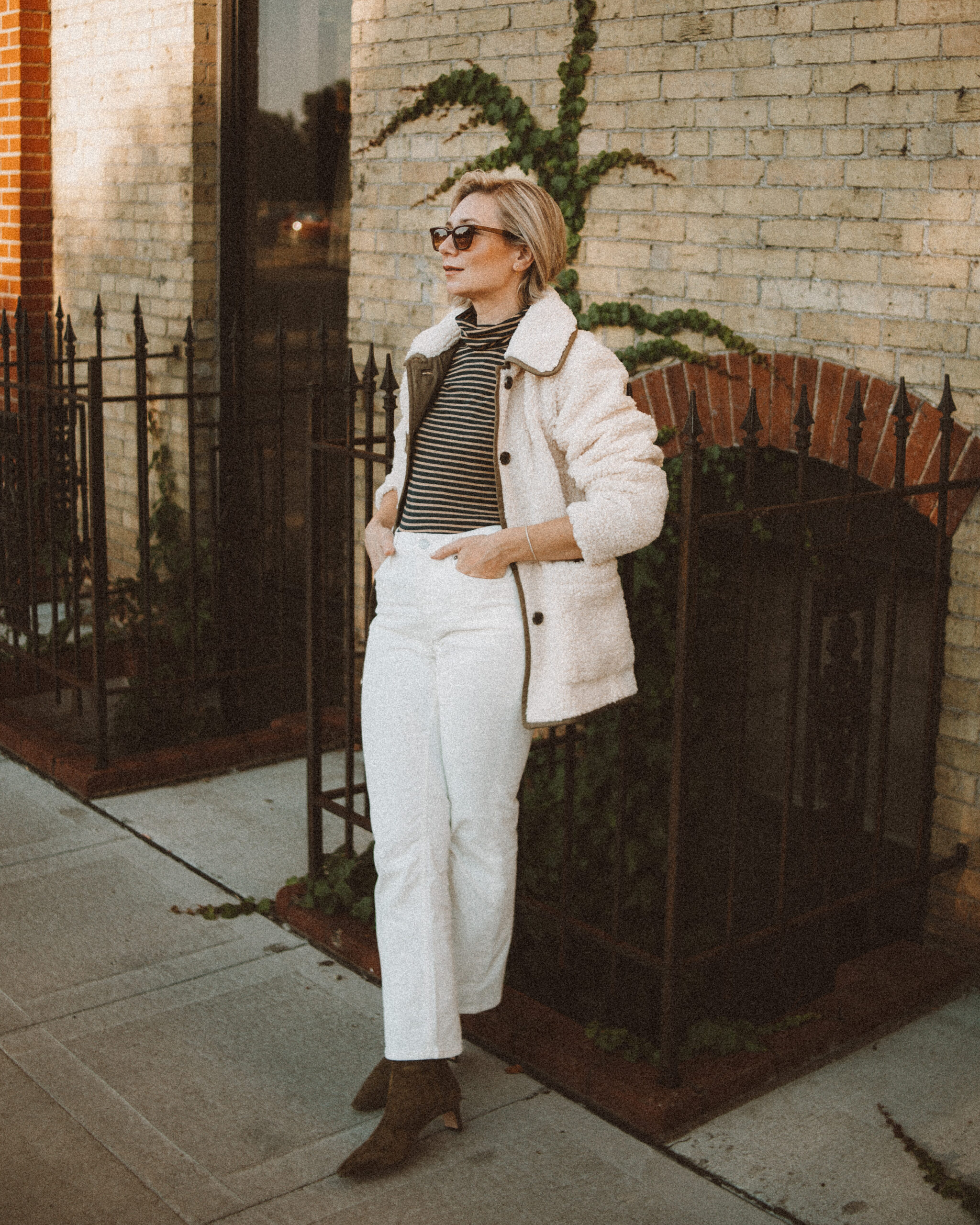 Karin Emily wears the perfect pair of corduroy pants with a striped turtleneck, sherpa jacket, and heeled booties