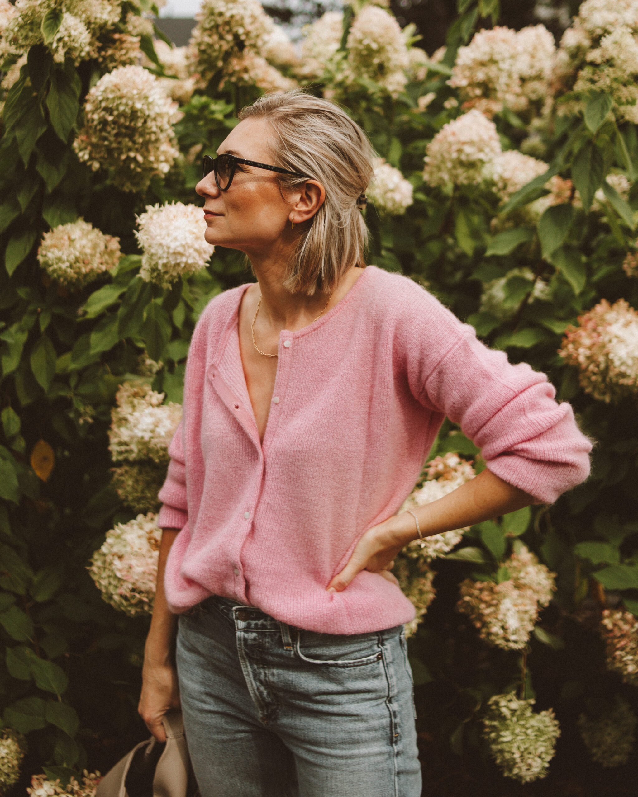 Karin Emily wears a cotton candy pink sezane gaspard jumper with a pair of light wash citizens of humanity charlotte jeans