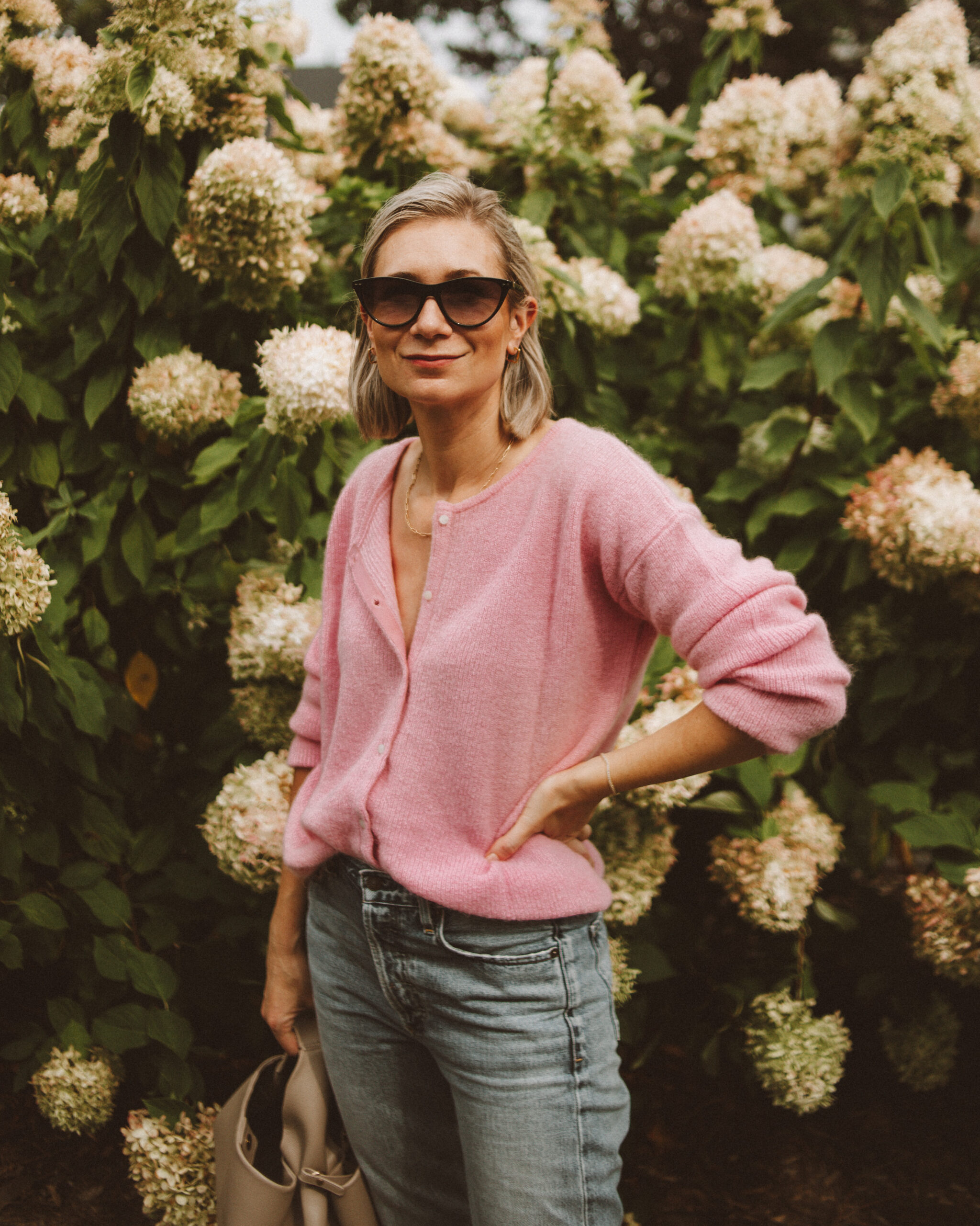 Karin Emily wears a cotton candy pink sezane gaspard jumper with a pair of light wash citizens of humanity charlotte jeans