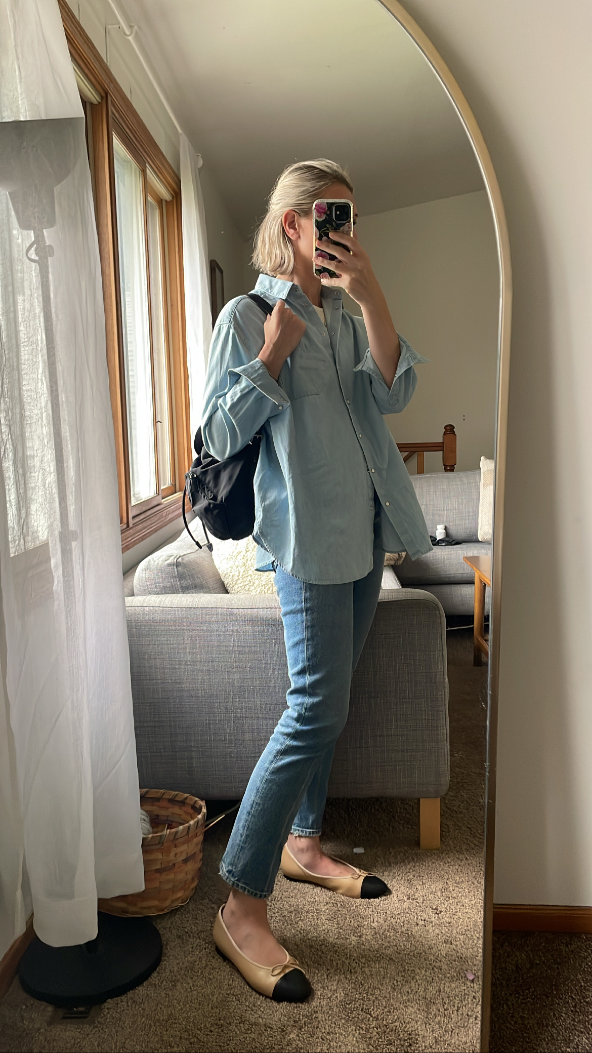 Karin Emily wears the Max Shirt from Sezane in a light chambray, citizens of humanity jolene jeans, and a black prada backpack