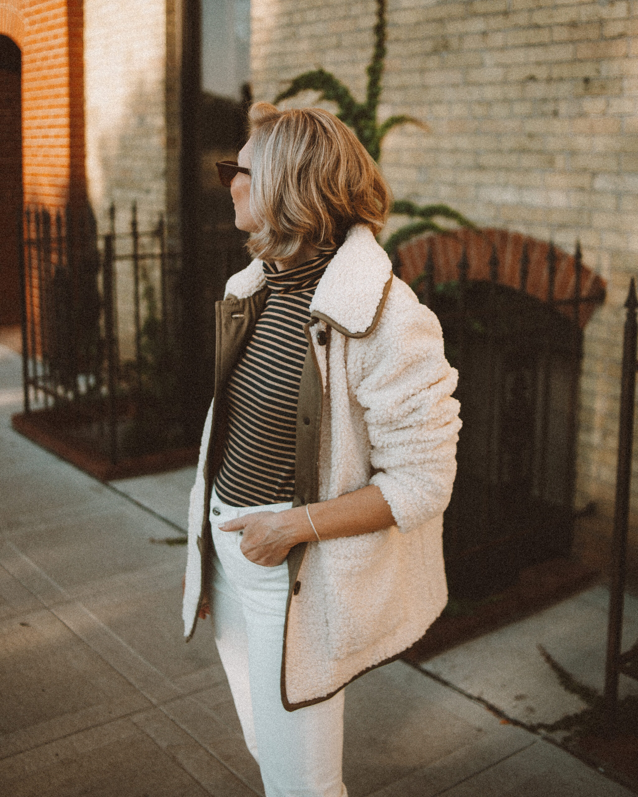Karin Emily wears the perfect pair of corduroy pants with a striped turtleneck, and sherpa jacket