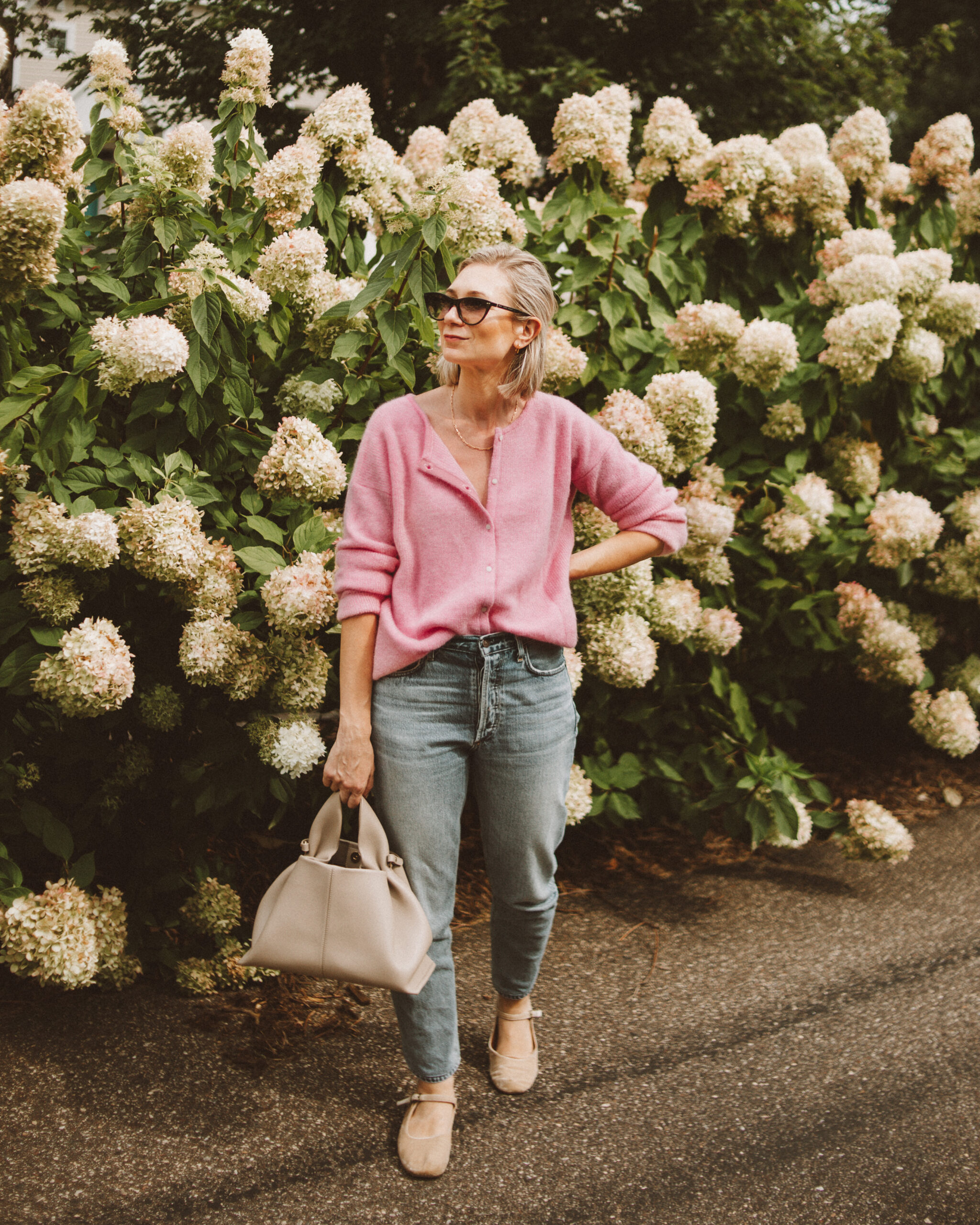 Karin Emily wears a cotton candy pink sezane gaspard jumper with a pair of light wash citizens of humanity charlotte jeans