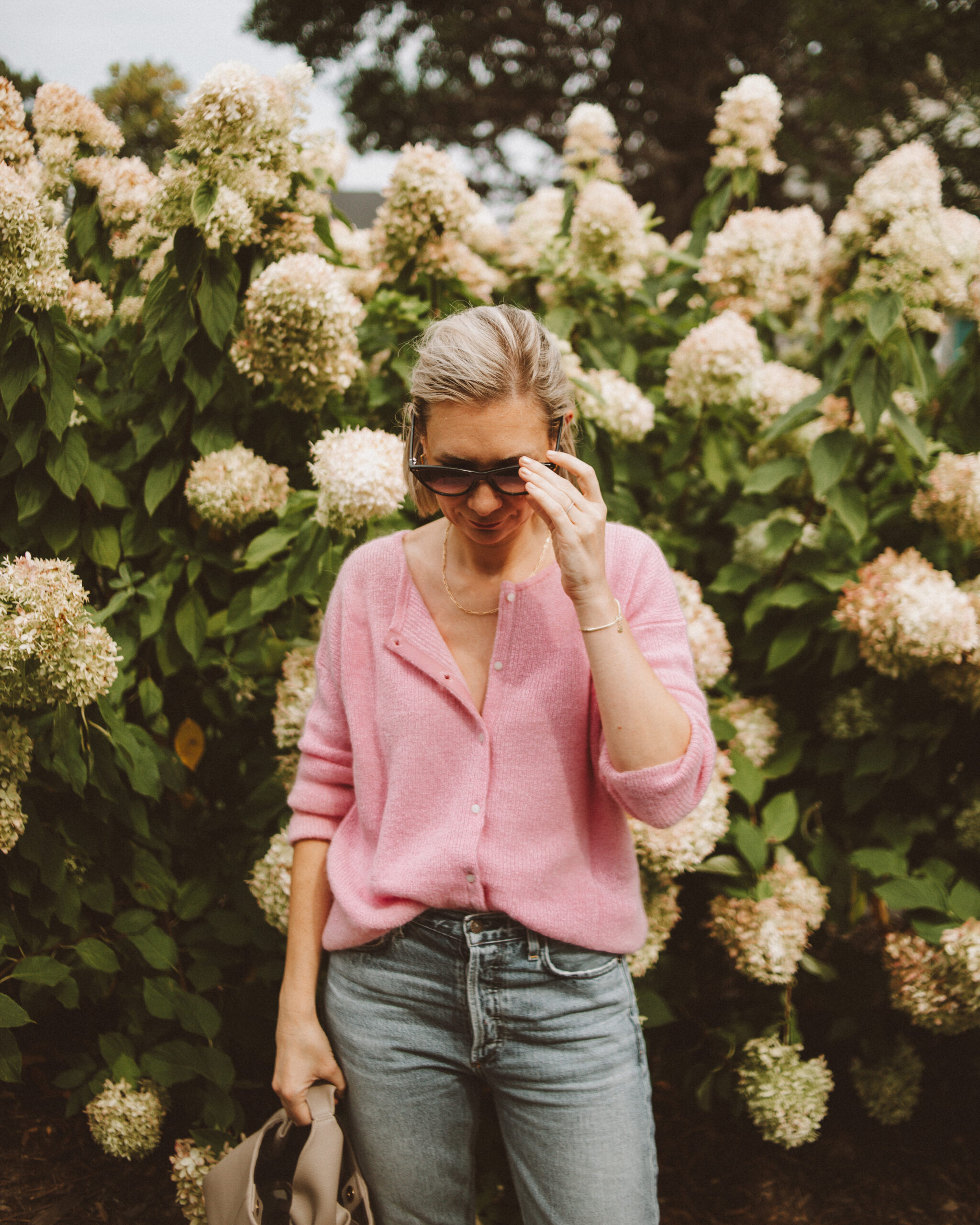 Karin Emily wears a cotton candy pink sezane gaspard jumper with a pair of light wash citizens of humanity charlotte jeans
