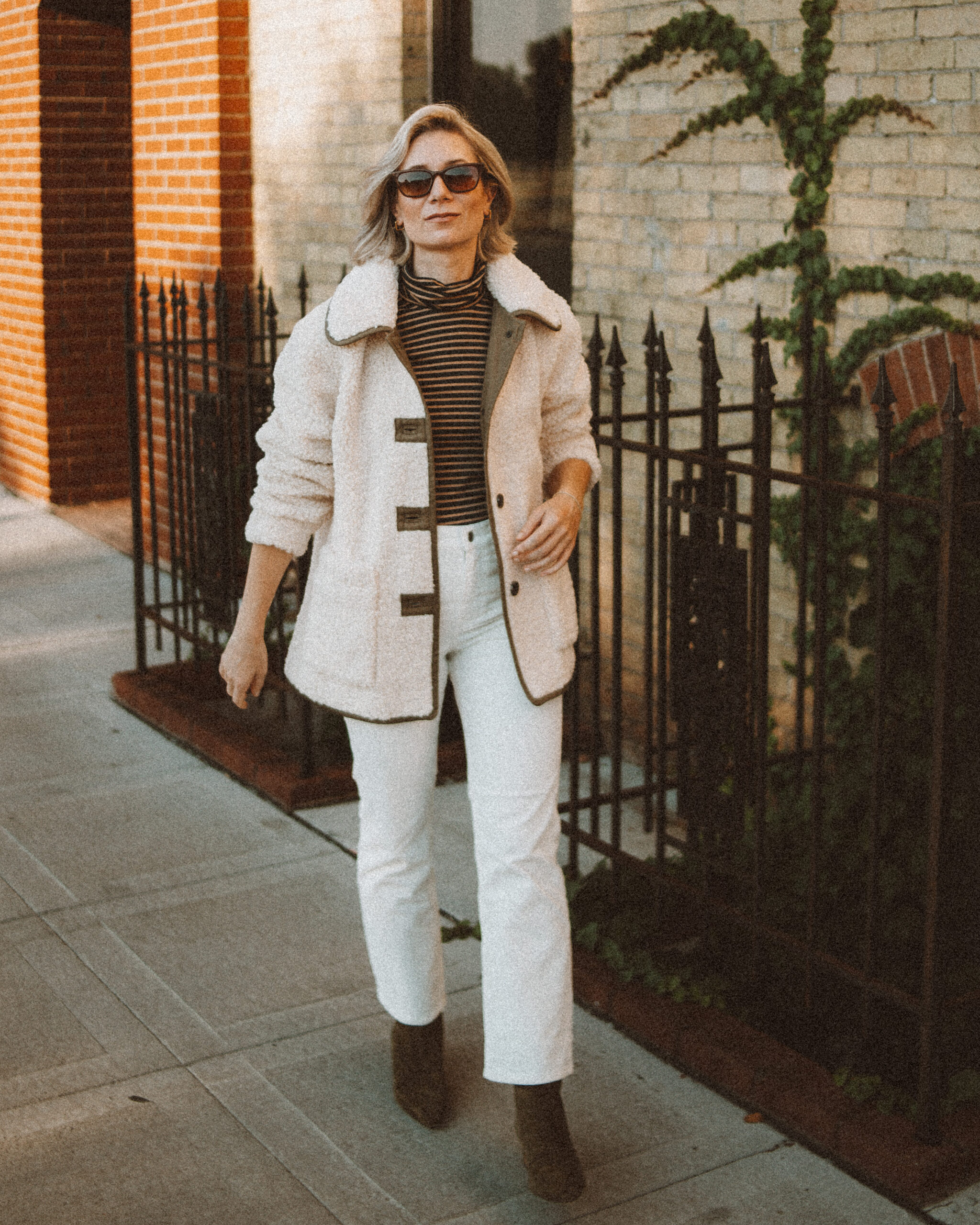 Karin Emily wears the perfect pair of corduroy pants with a striped turtleneck, sherpa jacket, and heeled booties
