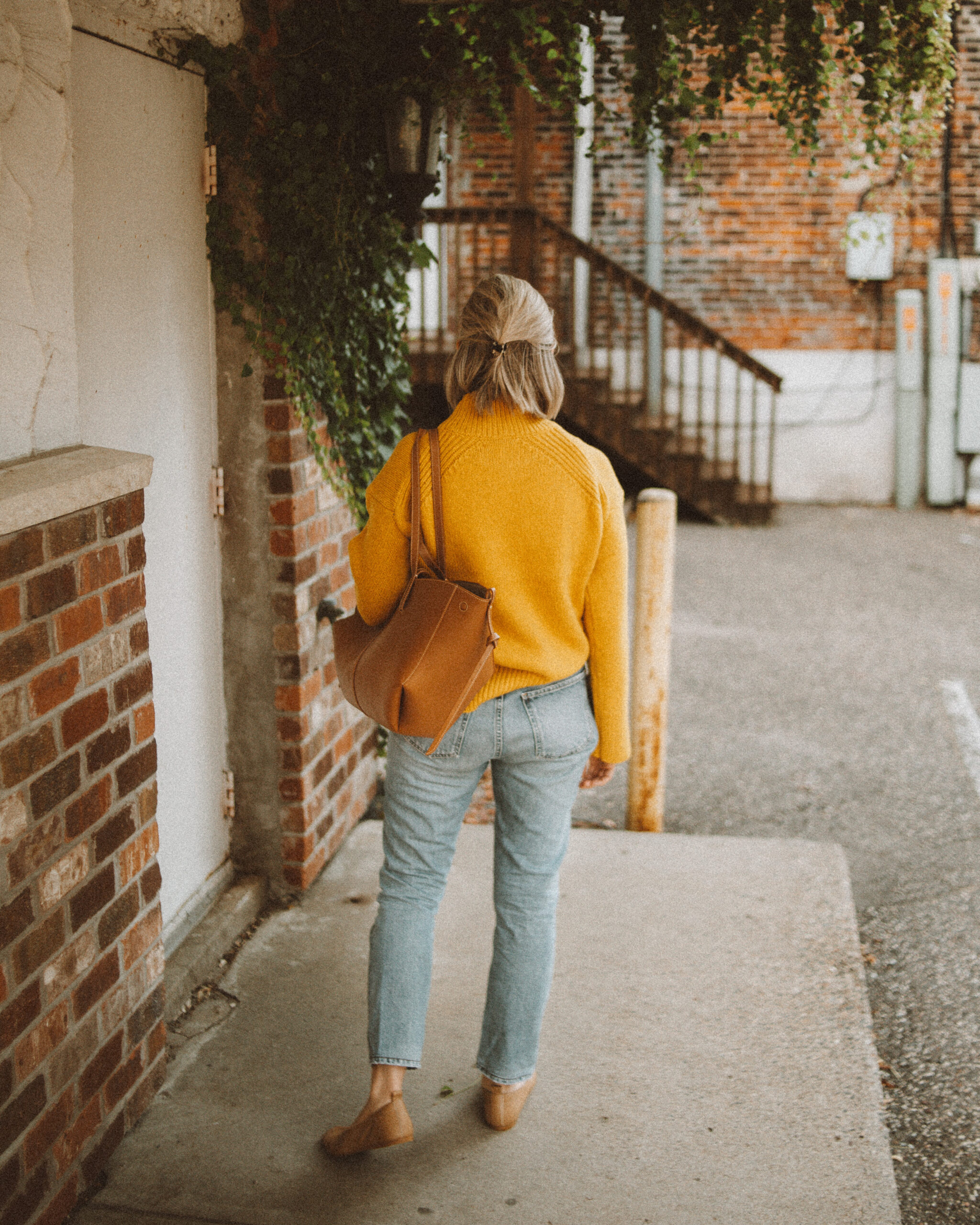 Karin Emily wears a goldenrod yellow turtleneck sweater from Alex Mill with her favorite Charlotte Jeans from CItizens of Humanity, a Polene Cyme Bag, Everlane Day Glove Flats, and chunky gold jewelry