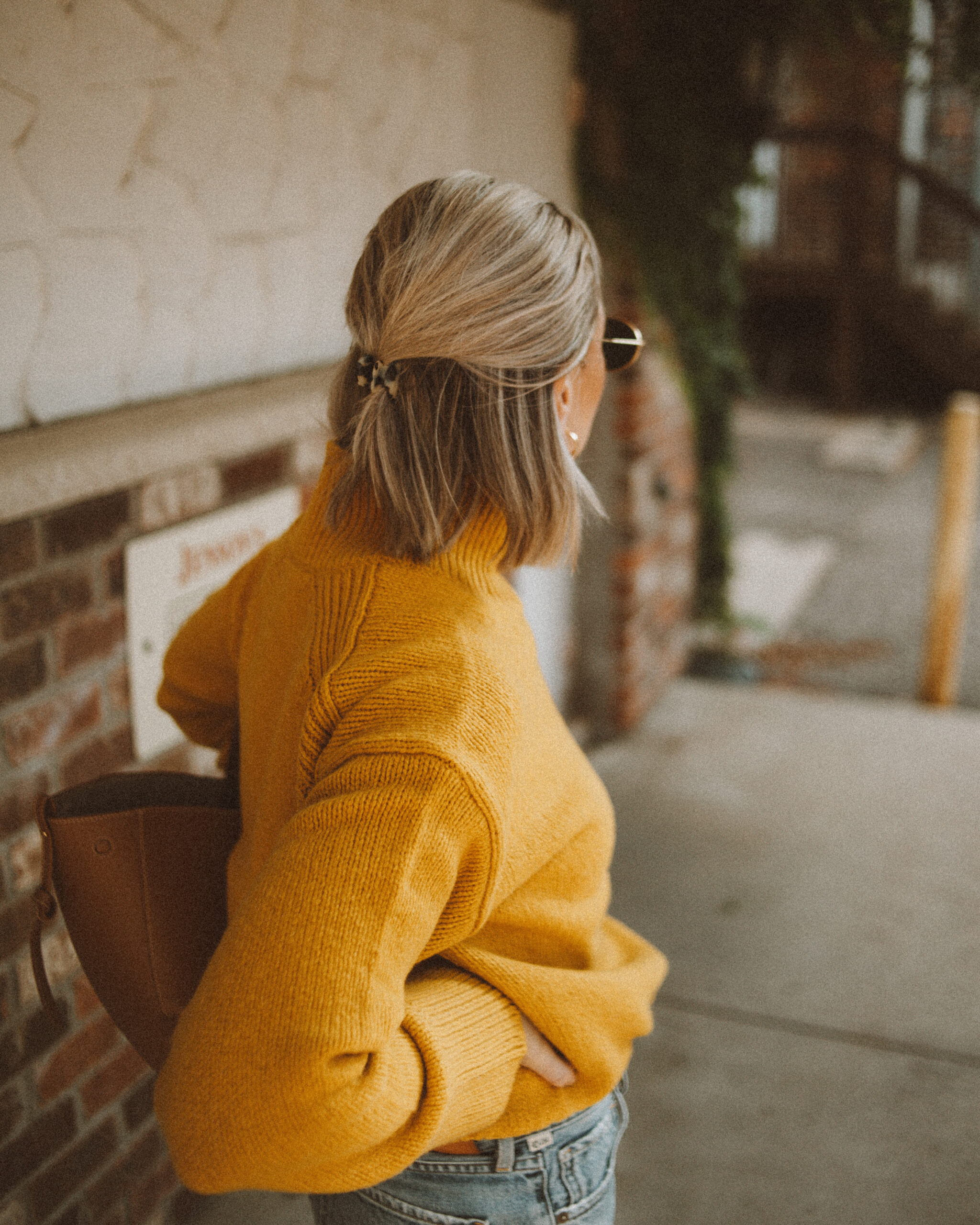 Karin Emily wears a goldenrod yellow turtleneck sweater from Alex Mill with her favorite Charlotte Jeans from CItizens of Humanity, a Polene Cyme Bag, Everlane Day Glove Flats, and chunky gold jewelry