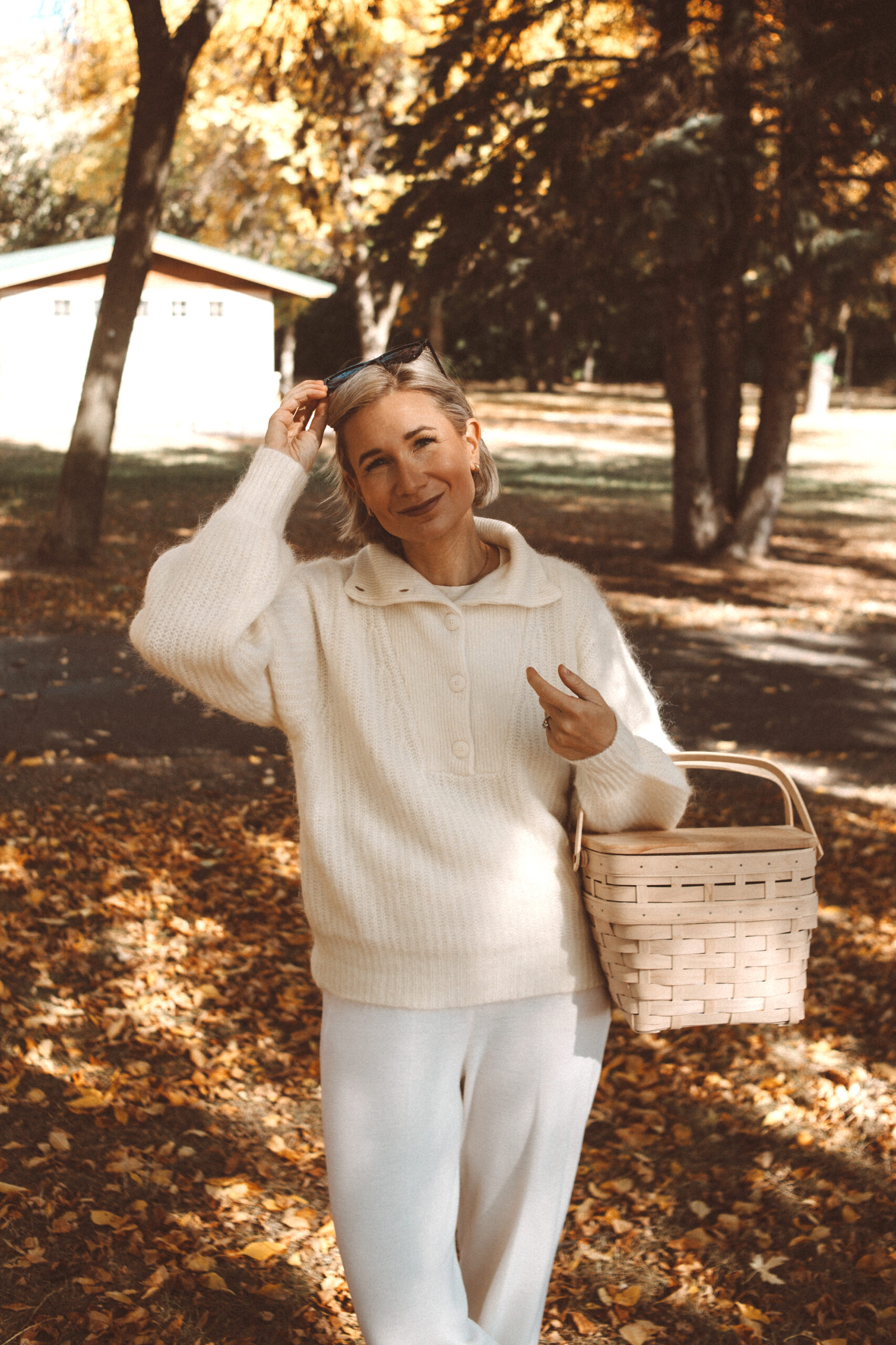 Karin Emily wears the coziest fall loungewear: a a collared sweater and white wide leg sweater pants with white sneakers 