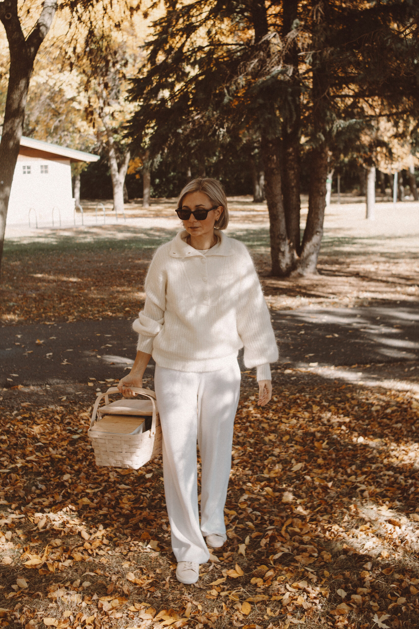 Karin Emily wears the coziest fall loungewear: a a collared sweater and white wide leg sweater pants with white sneakers