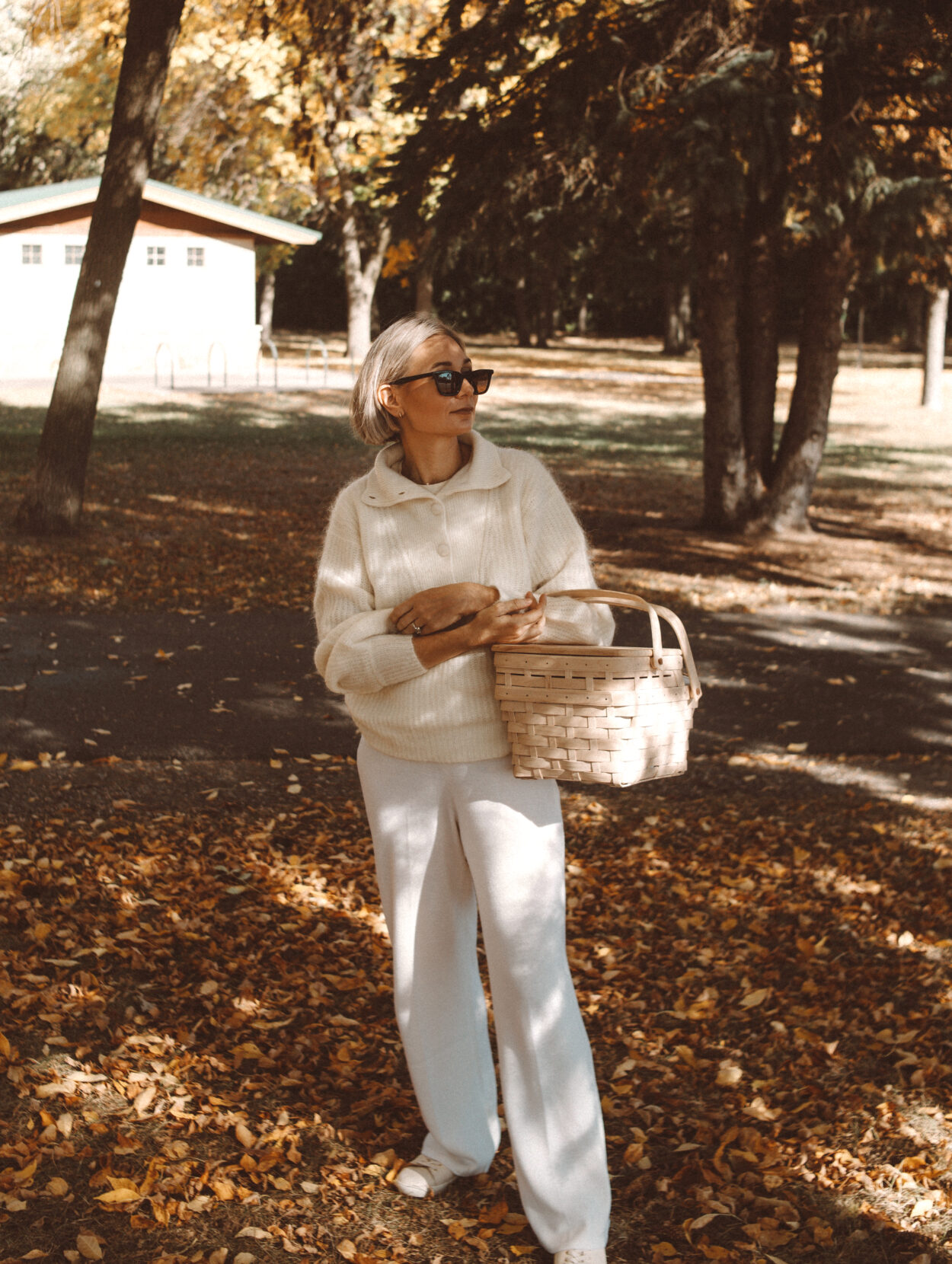 Karin Emily wears the coziest fall loungewear: a a collared sweater and white wide leg sweater pants with white sneakers